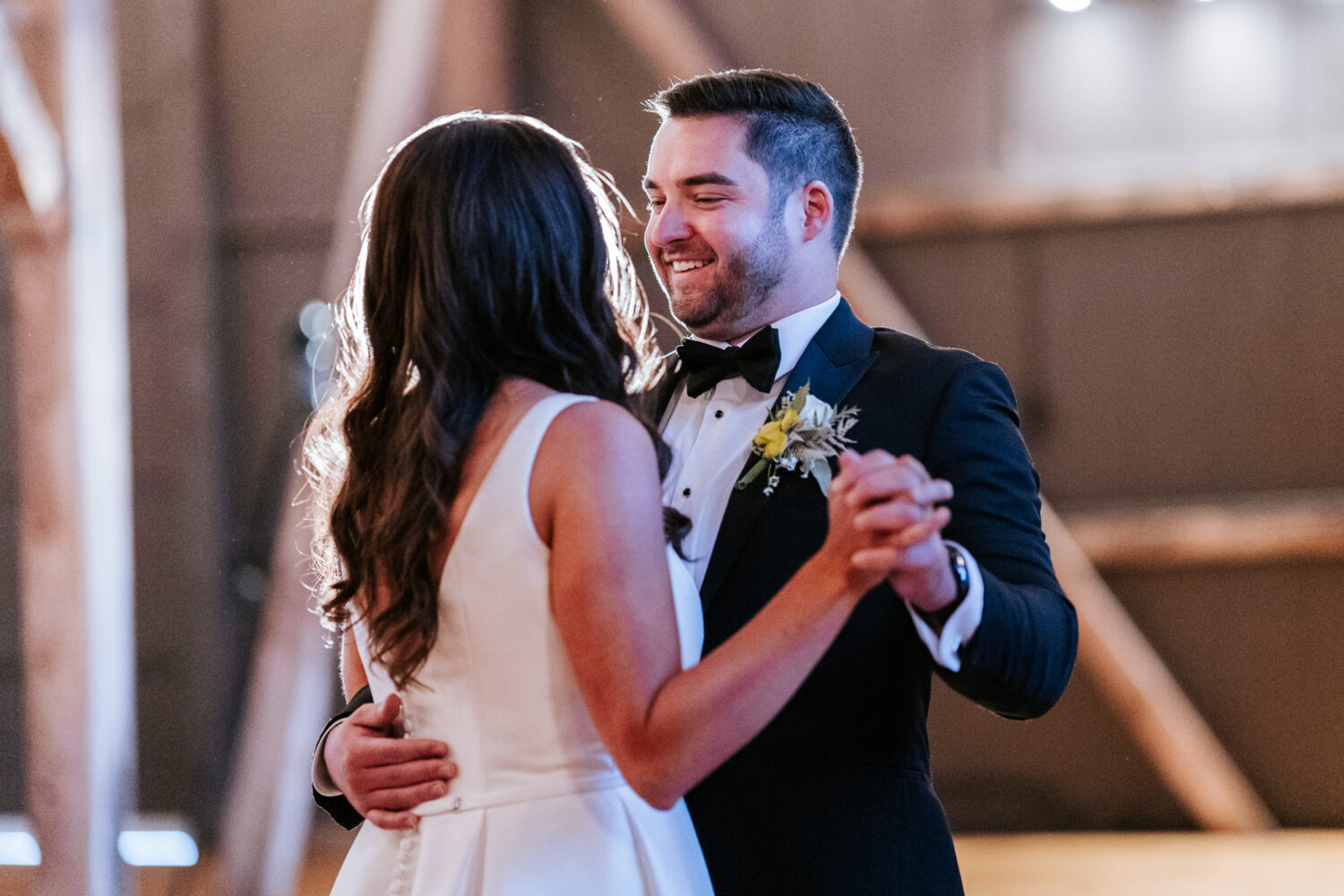 groom looking at his bride and smiling during their first dance