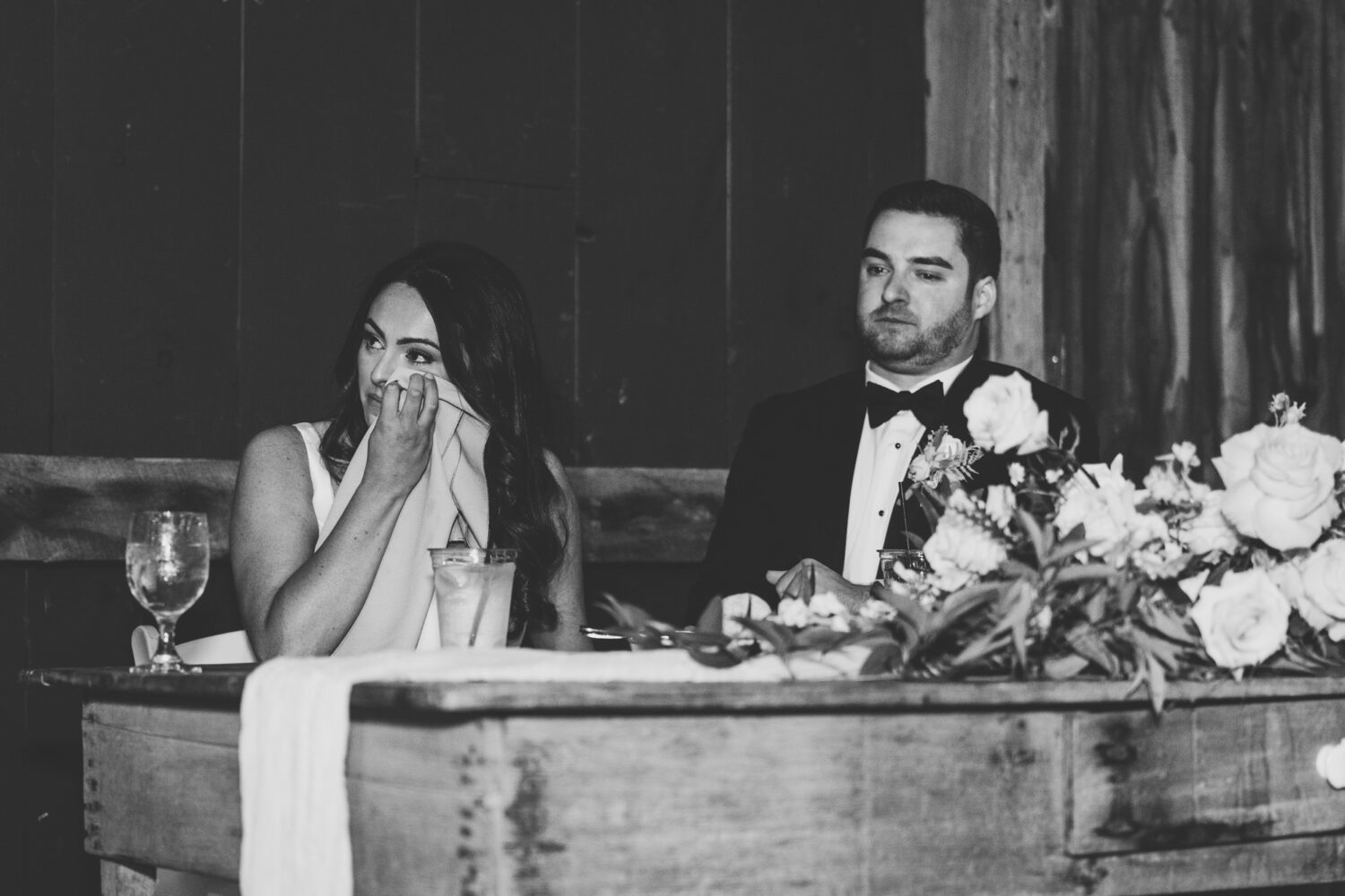 bride tearing up while listening to her sister give her wedding speech