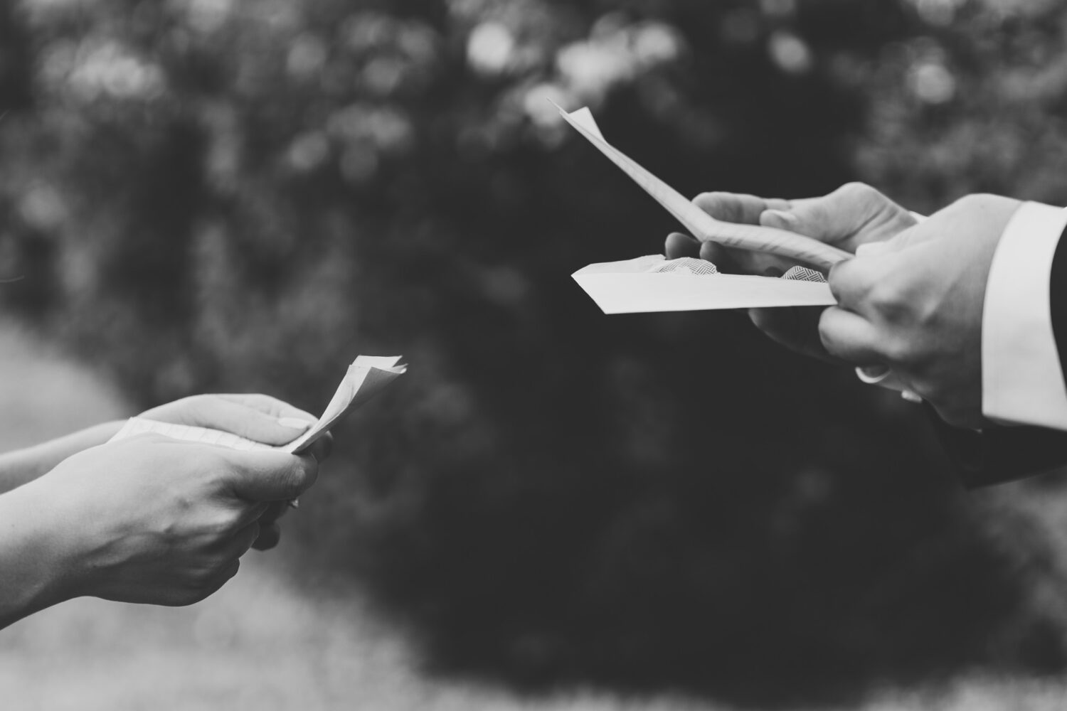 tight shot of the bride and groom's hands as they read each other's letters