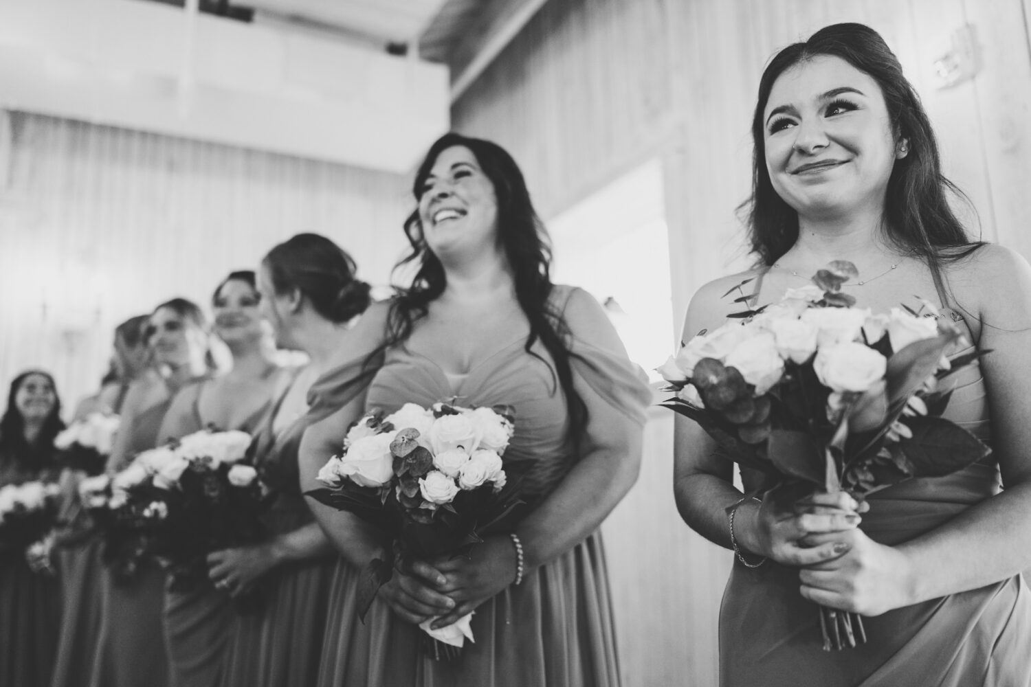 bridesmaids reacting to seeing the bride walk down the aisle during her Sweeney Barn wedding day