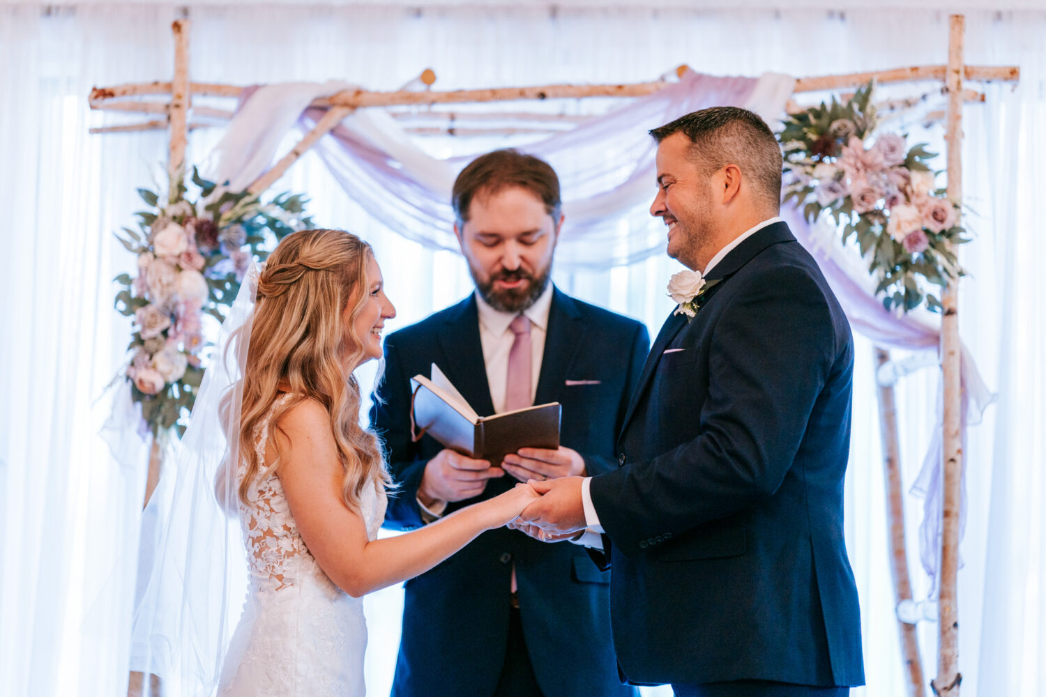 bride and groom exchanging rings during their Sweeney Barn wedding day