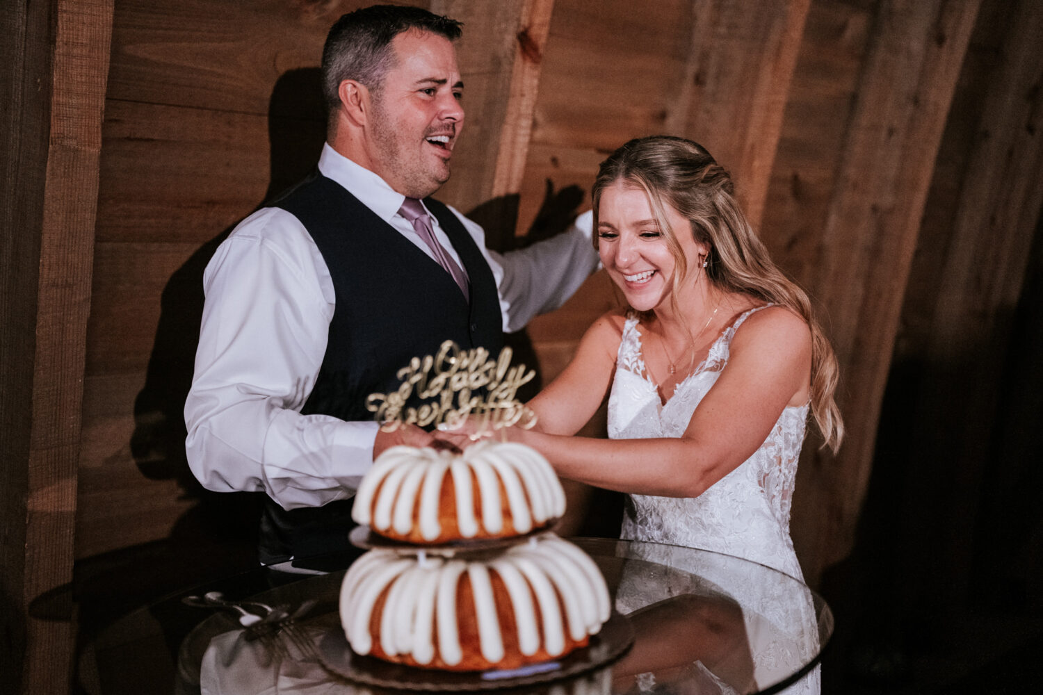 bride and groom cutting their wedding cake during their Sweeney Barn wedding day