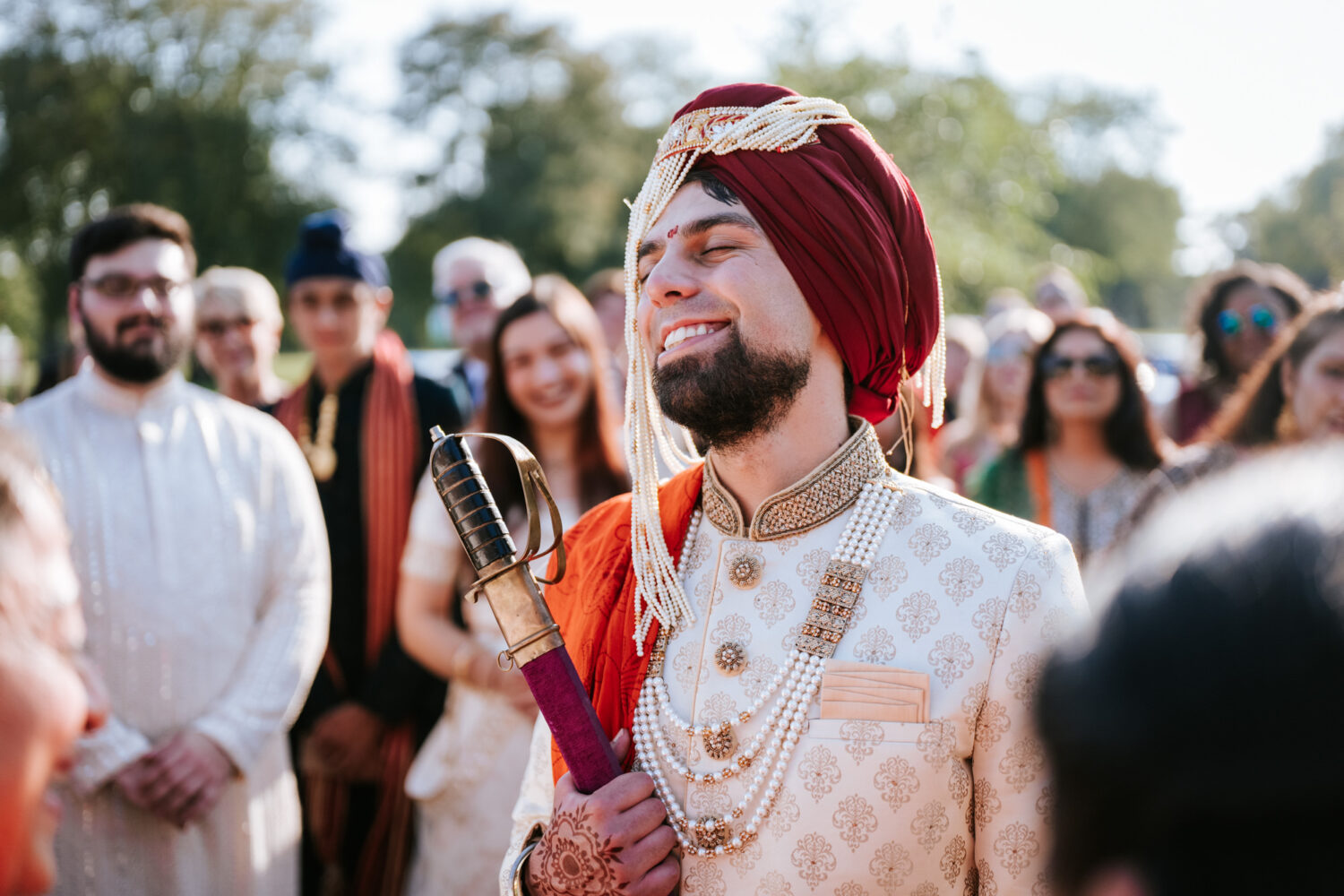 groom smiling as he enters his indian wedding ceremony