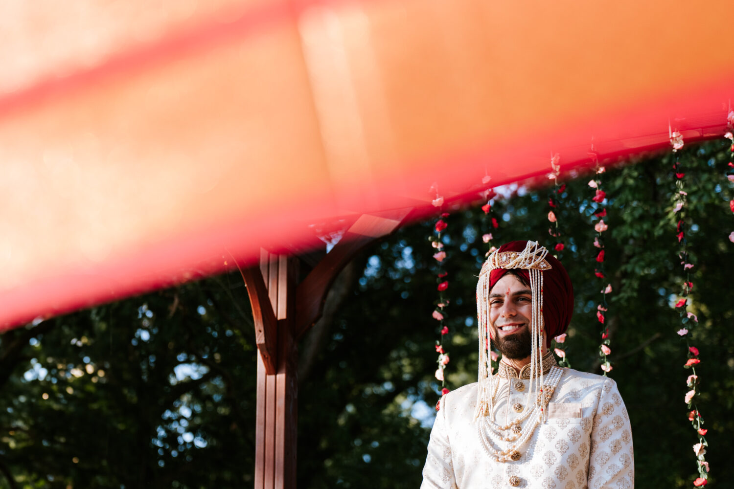 groom smiling as he's preparing to see his bride during their indian wedding ceremony
