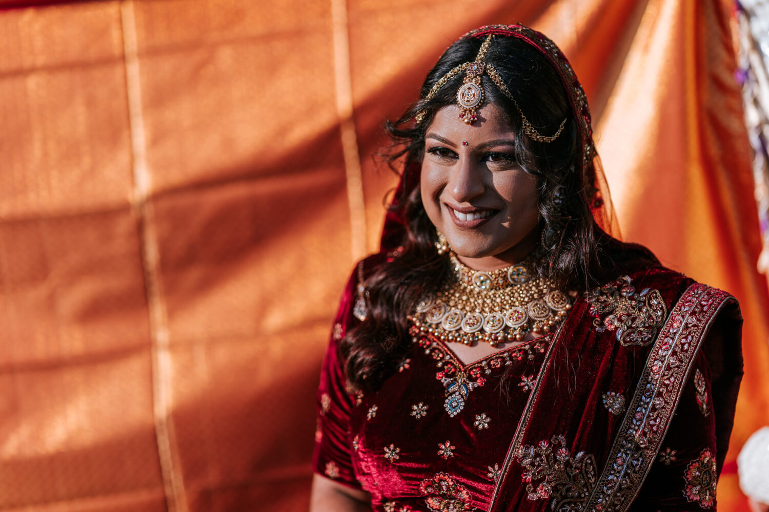 bride smiling as she's preparing to see her groom during their hindu wedding ceremony