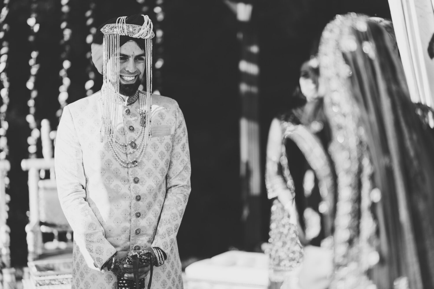 groom smiling as he see's his bride for the first time on their hindu wedding ceremony