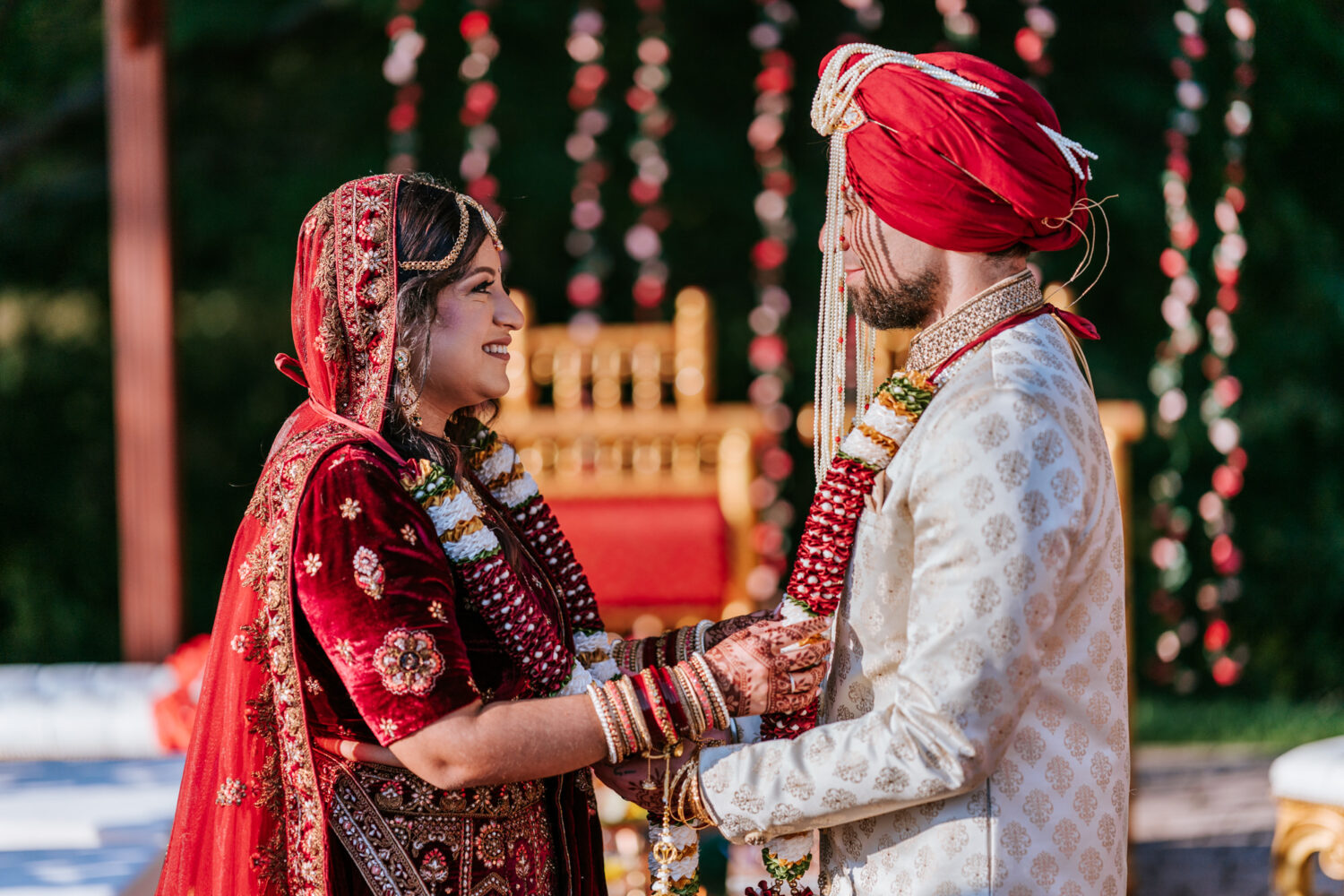 bride and groom smiling while looking at each other during their hindu wedding ceremony