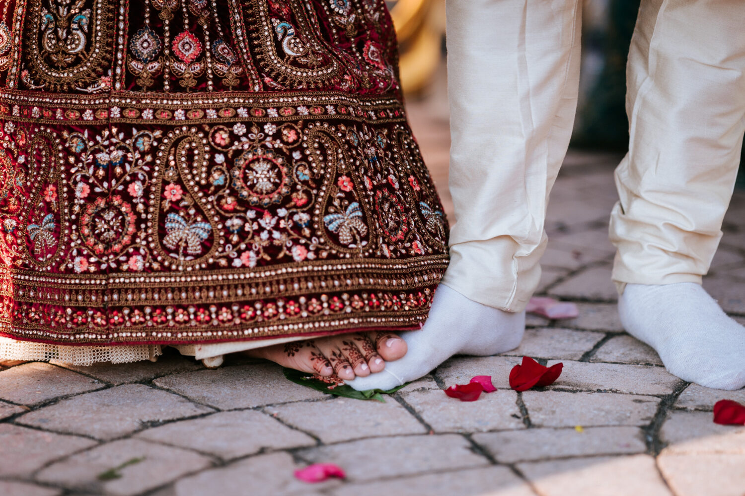 bride and groom stepping on leaves during their hindu wedding ceremony