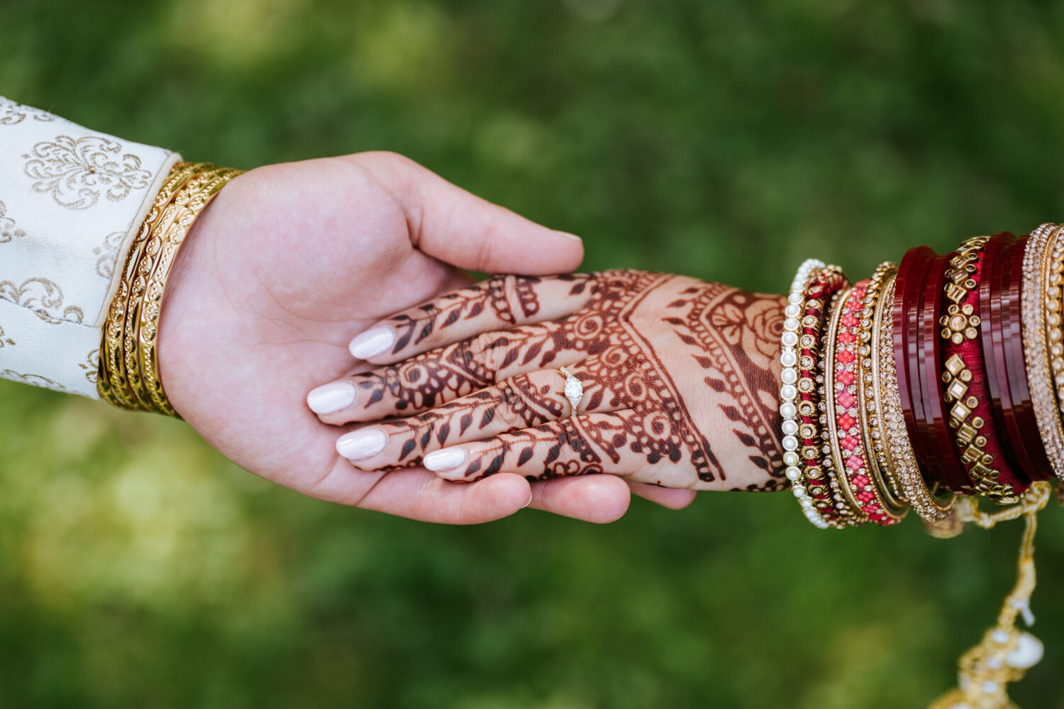 bride and groom holding hands and showing their henna on their wedding day