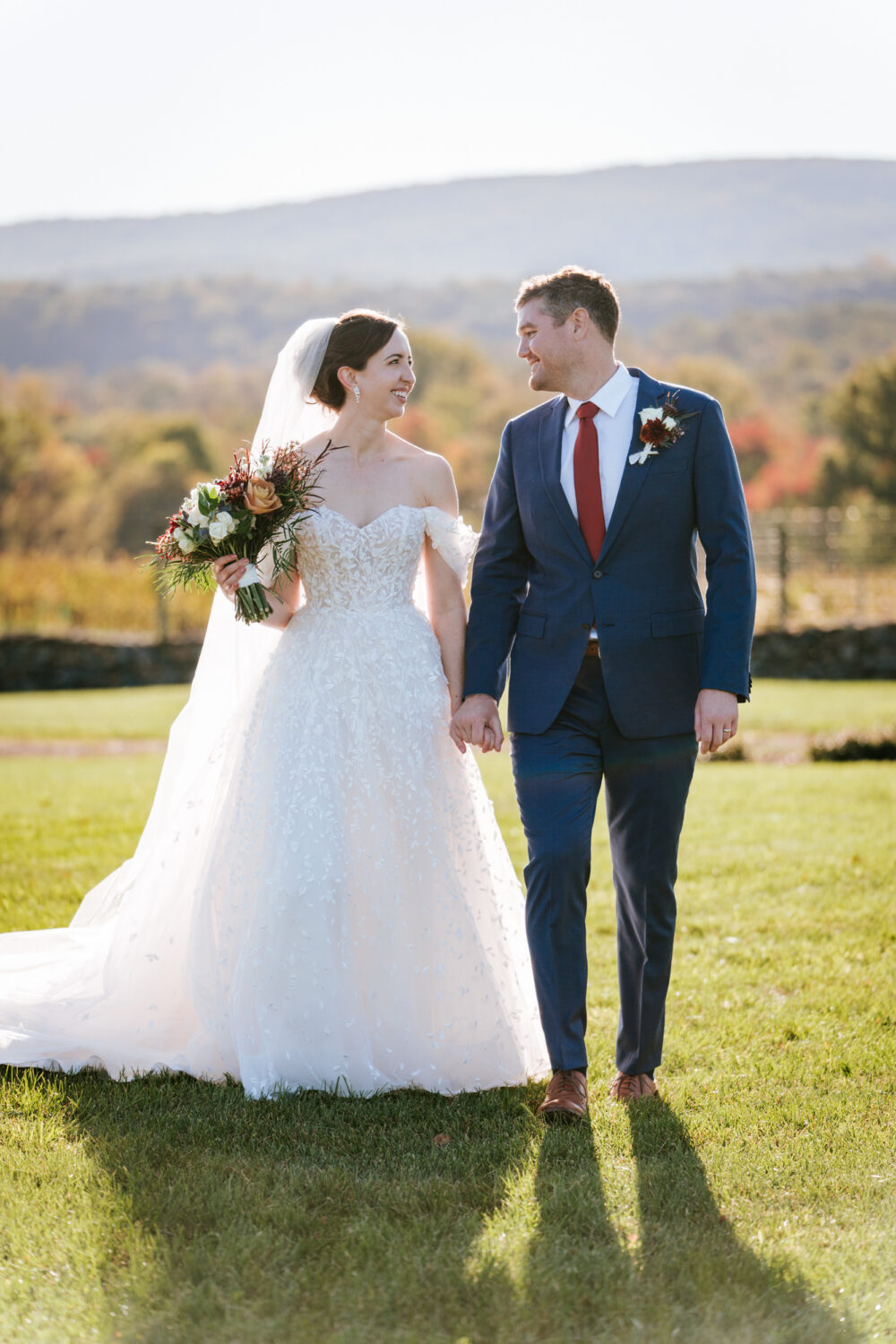 vertical portrait of the bride and groom walking together on their Kalero Vineyard wedding day