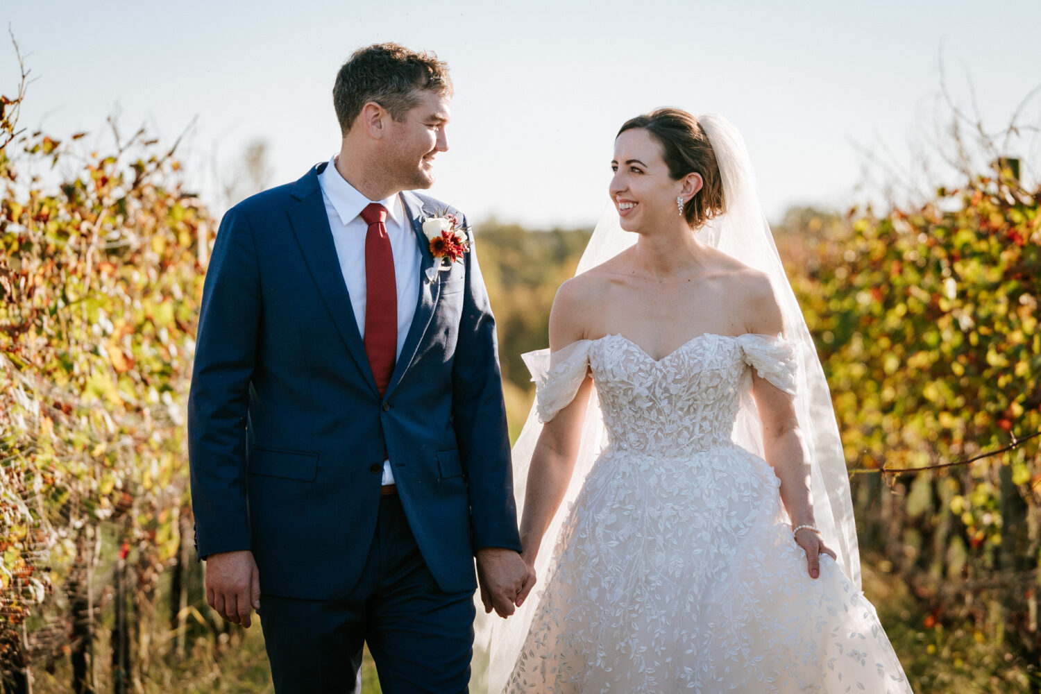 bride and groom walking through vineyard fields on their Kalero Vineyard wedding day