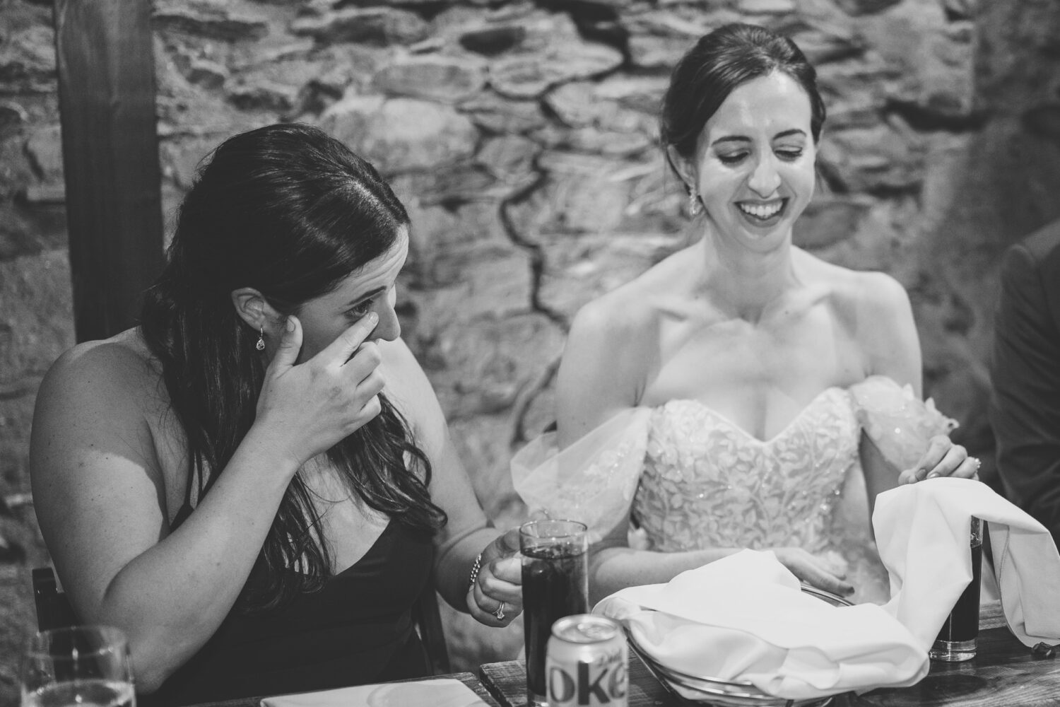 bride and her sister getting emotional together listening to their father's reception speech