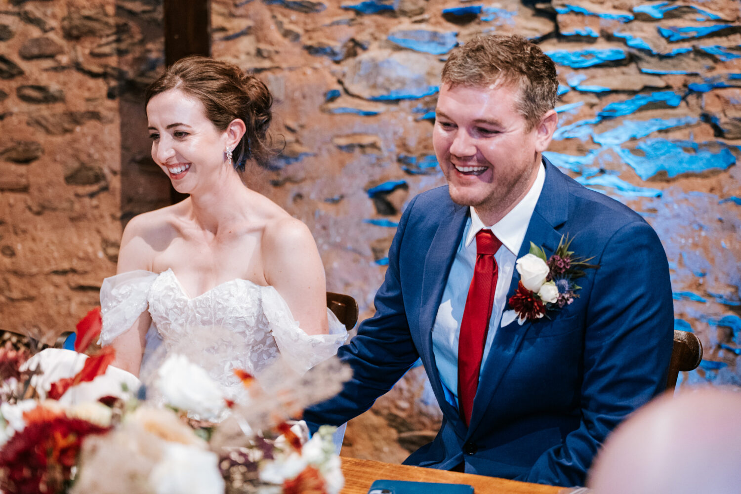 bride and groom laughing while listening to their Kalero Vineyard wedding day speeches