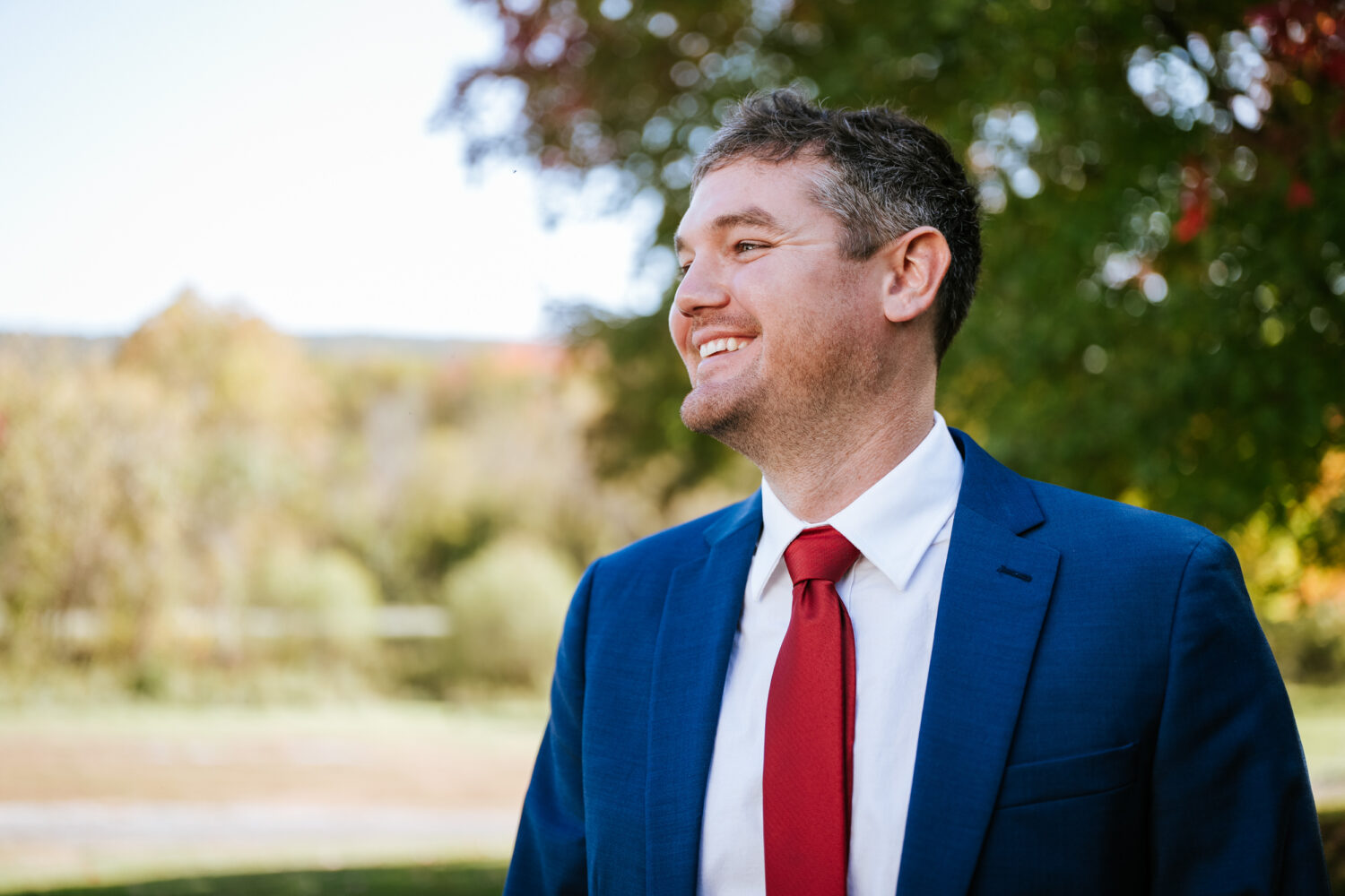 groom smiling and looking off into the distance