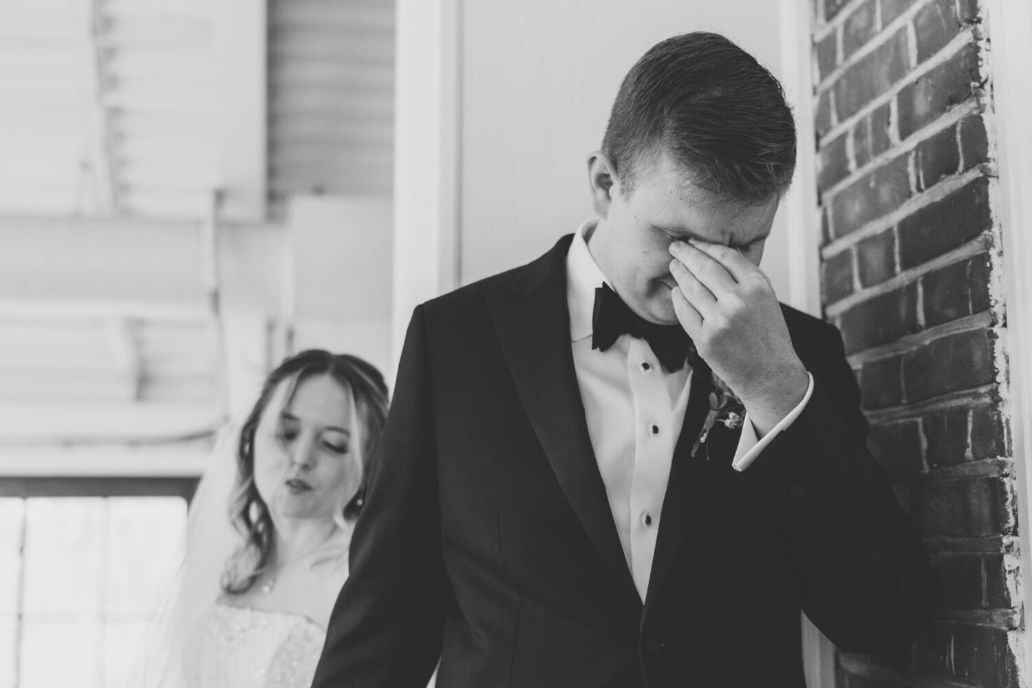 groom crying while bride is saying a prayer