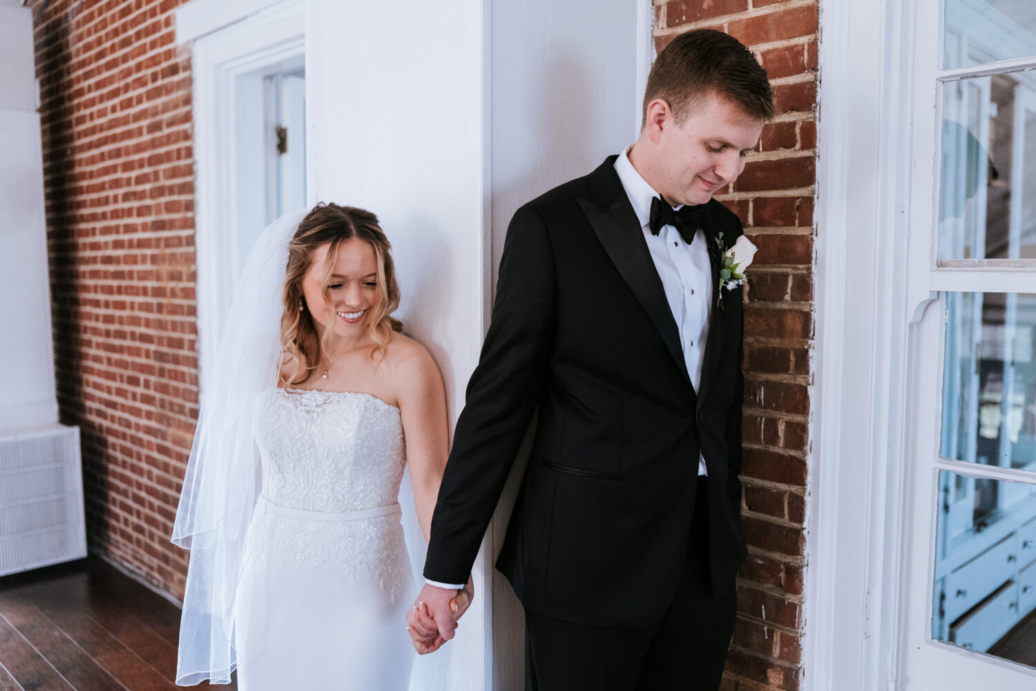 bride and groom interacting and holding hands during their first touch