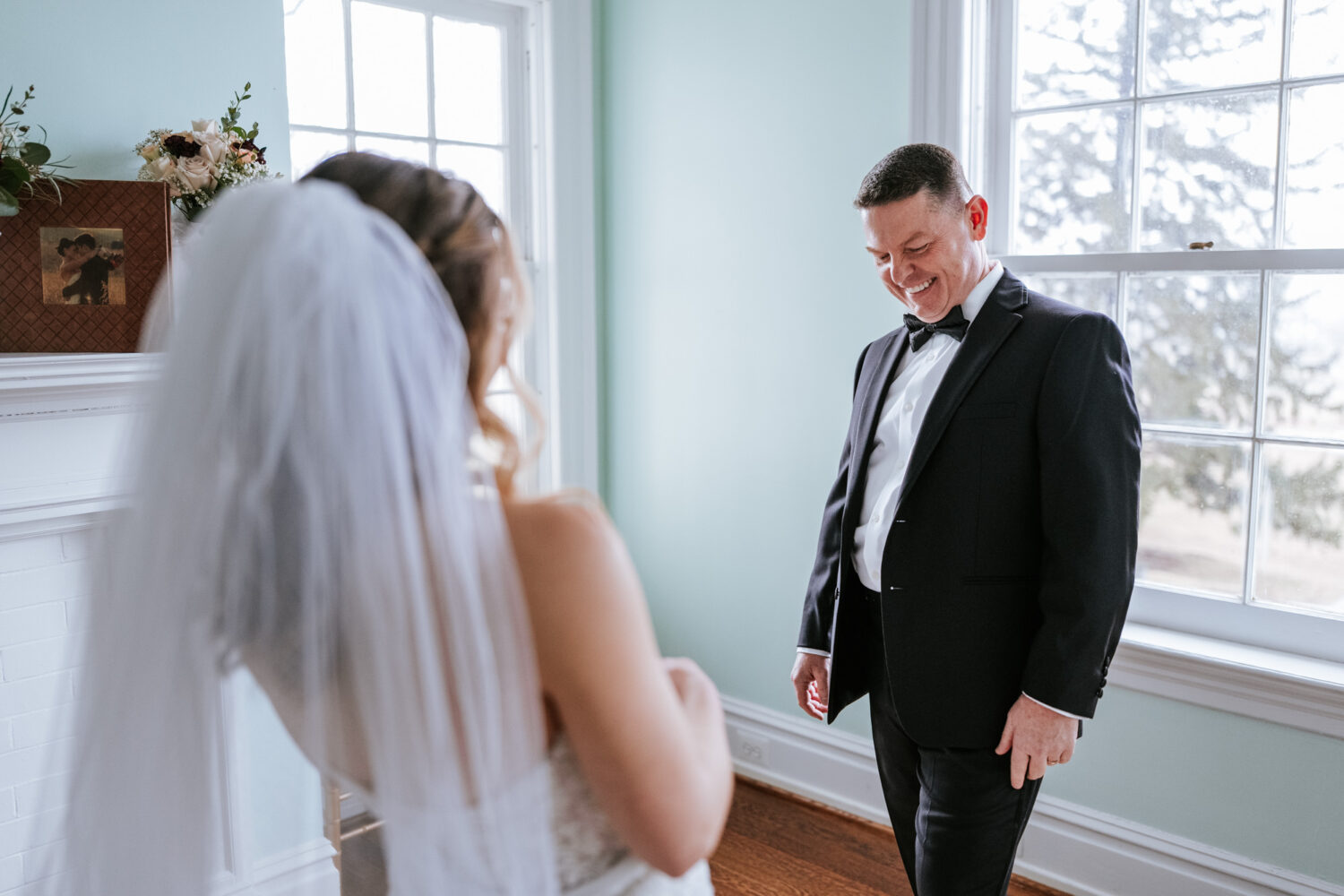 father of the bride smiling while seeing his daughter in her wedding dress for the first time