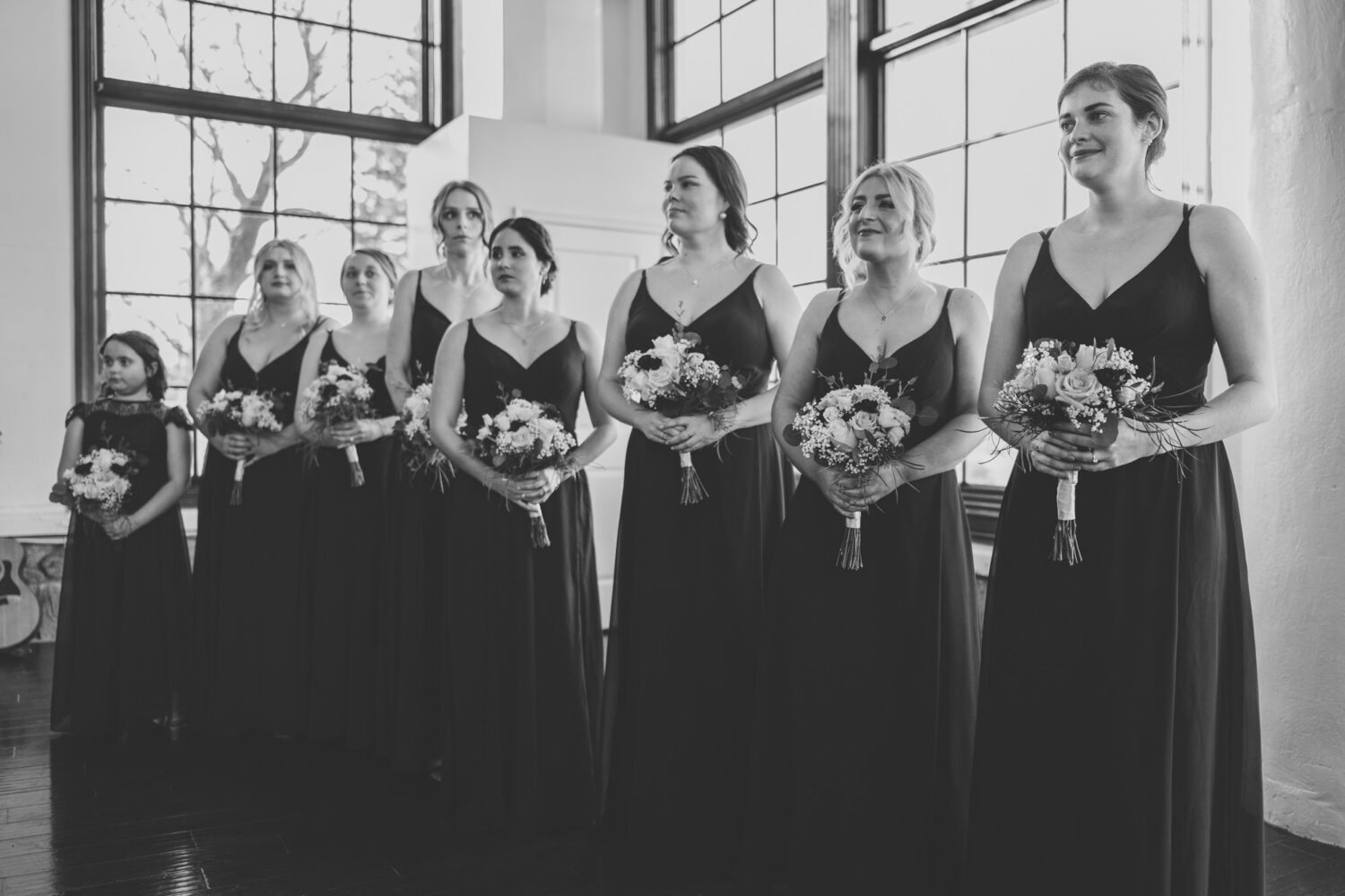 bridesmaids smiling while watching bride walk down the aisle