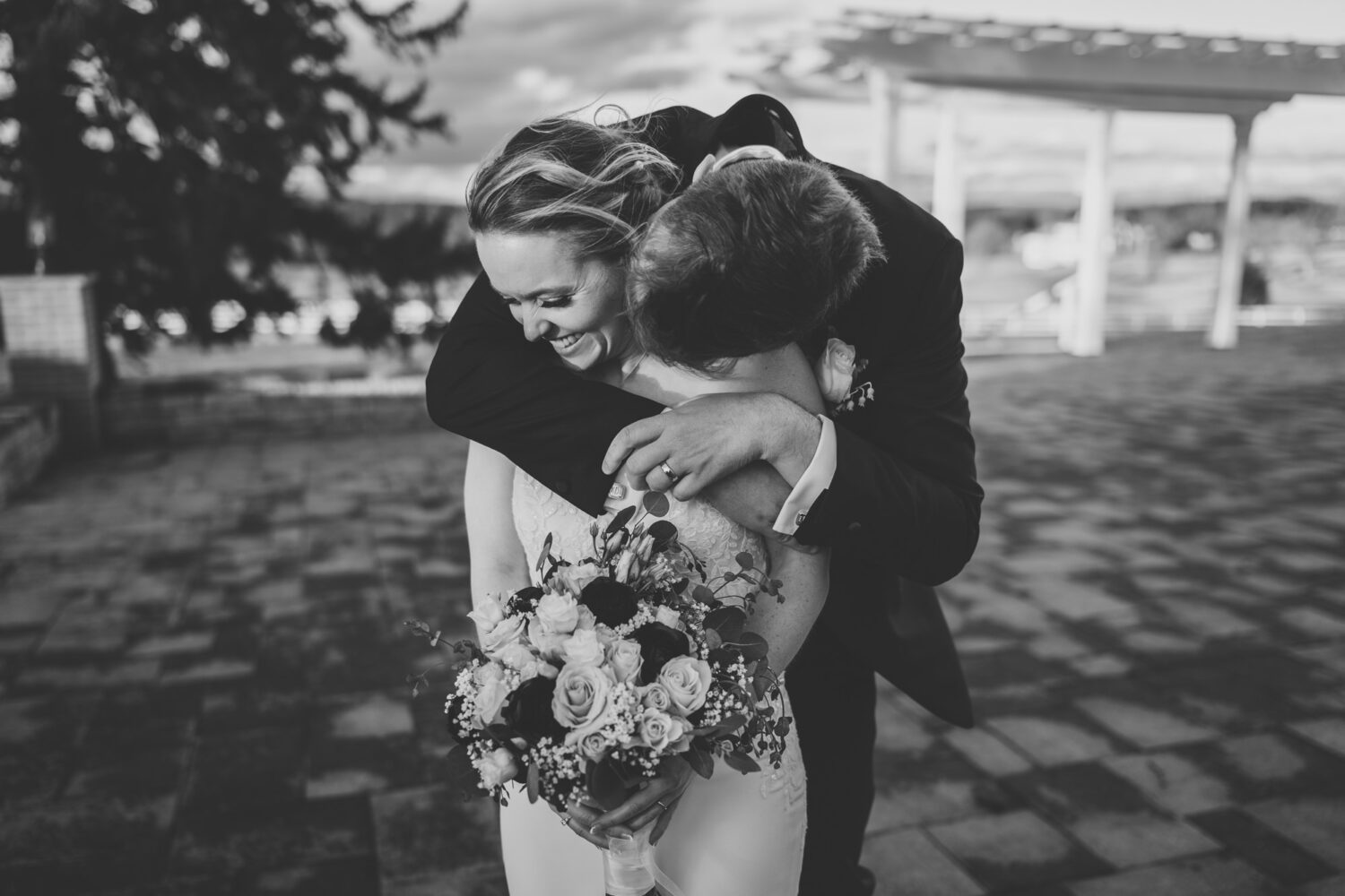 groom hugging bride from behind 