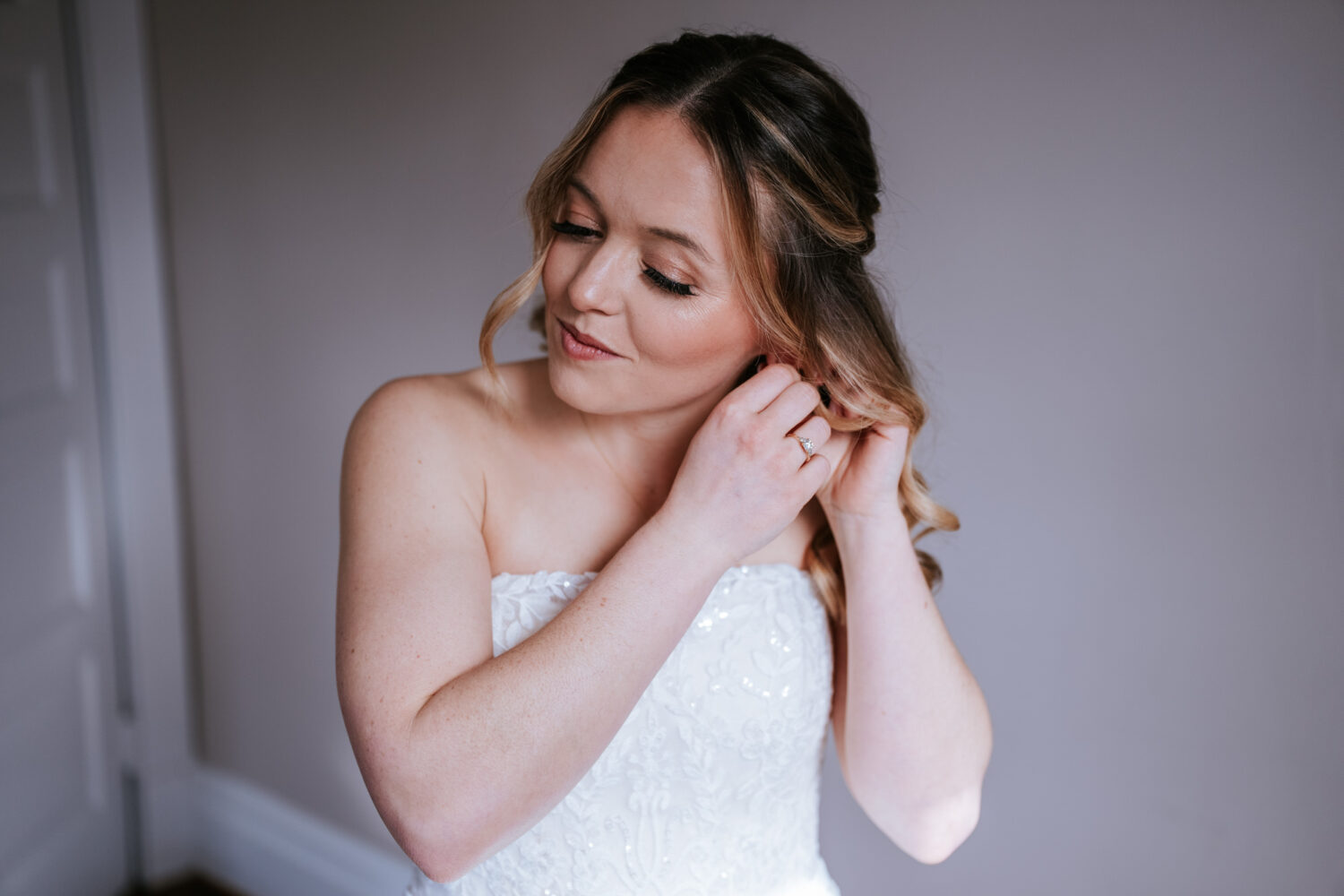 bride adjusting her earring before her wedding day