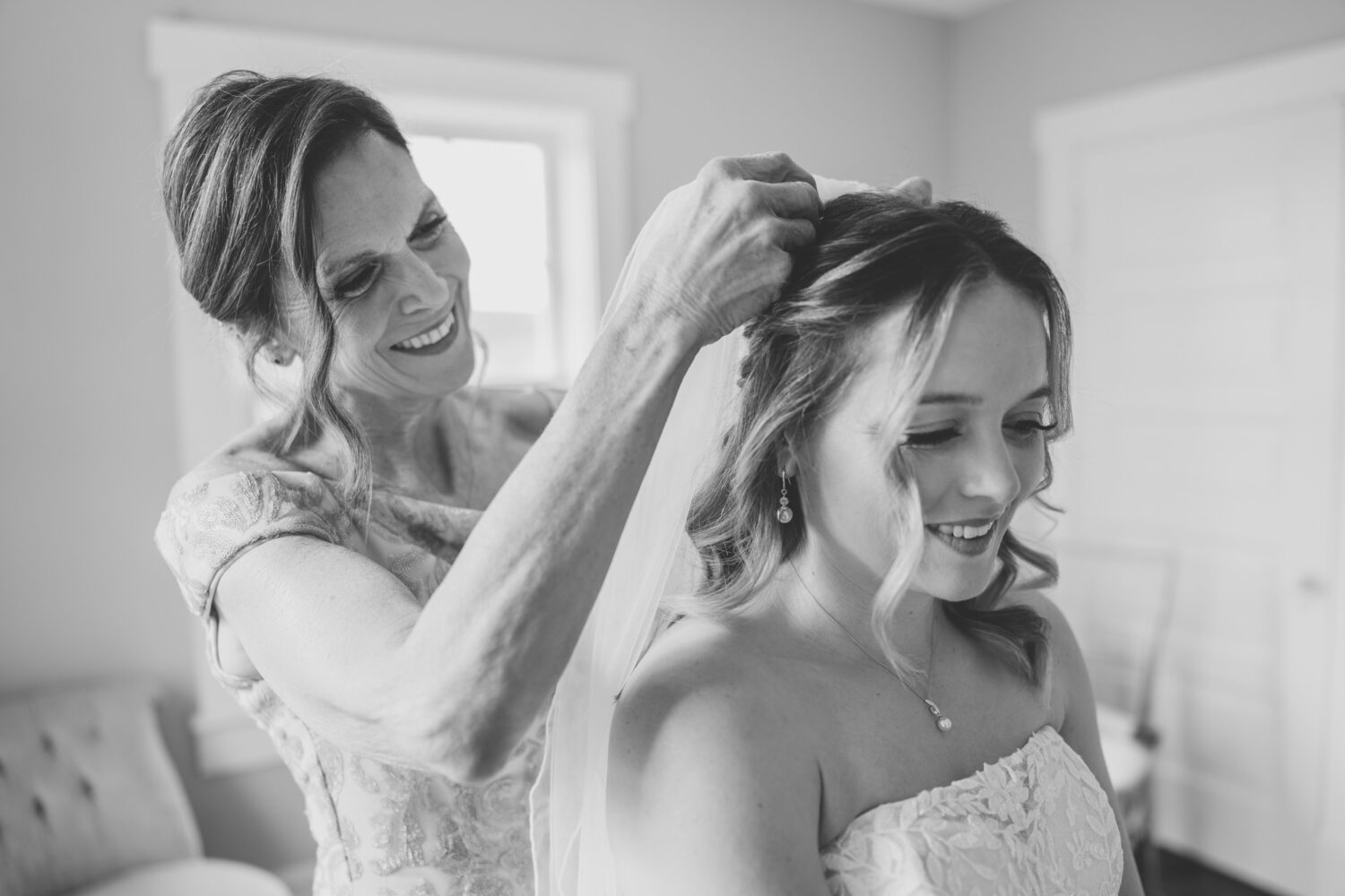 mother of the bride adjusting her daughter's veil