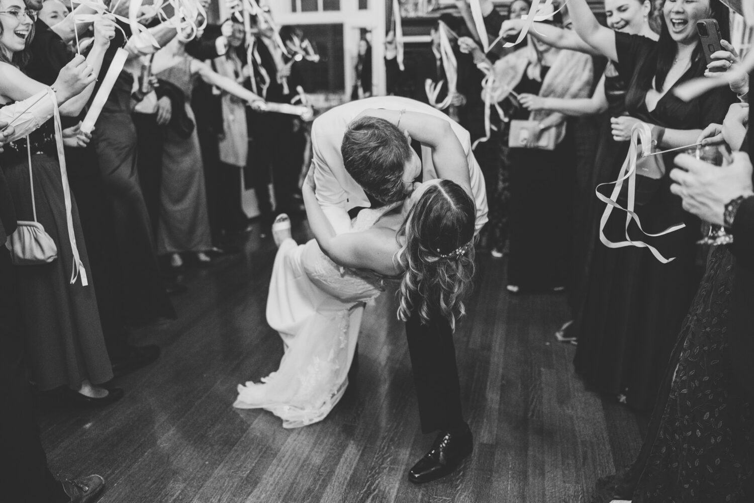 bride and groom final kiss as they exit their wedding reception