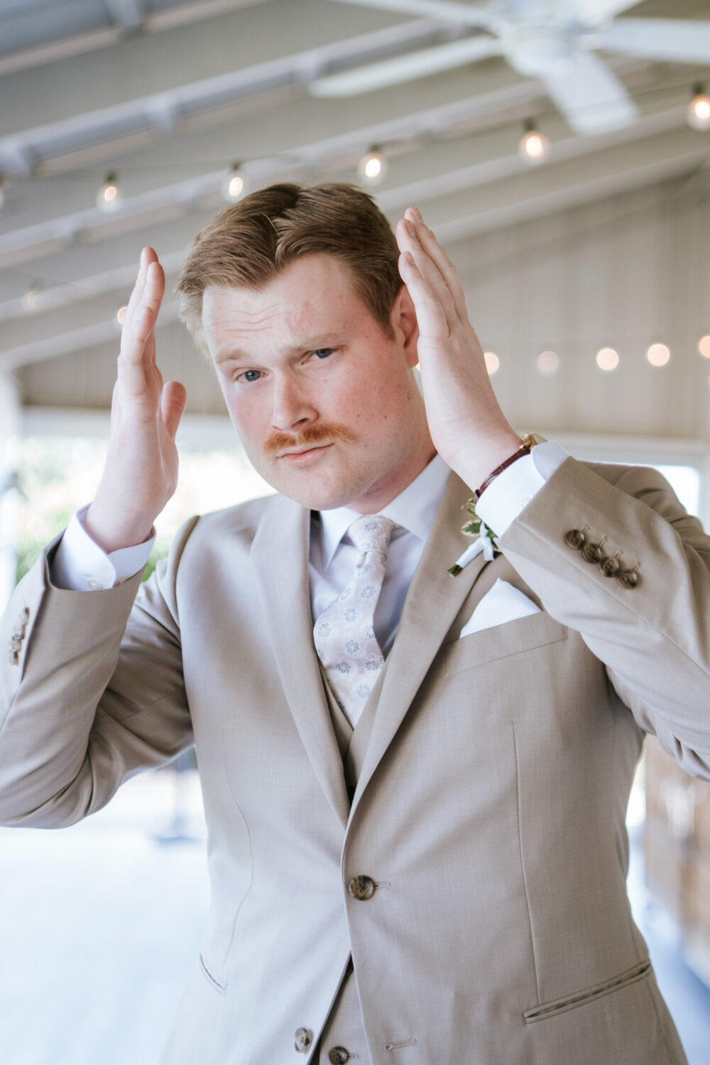 groom showing off his outfit and hair on his virginia wedding day