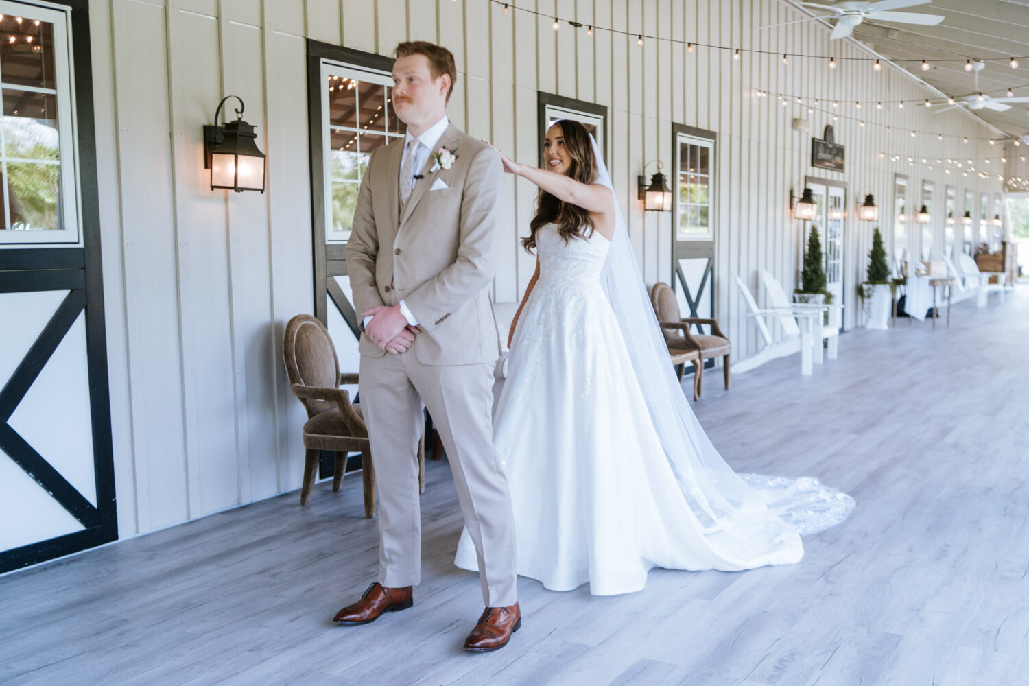bride tapping her groom on the shoulder for their first look