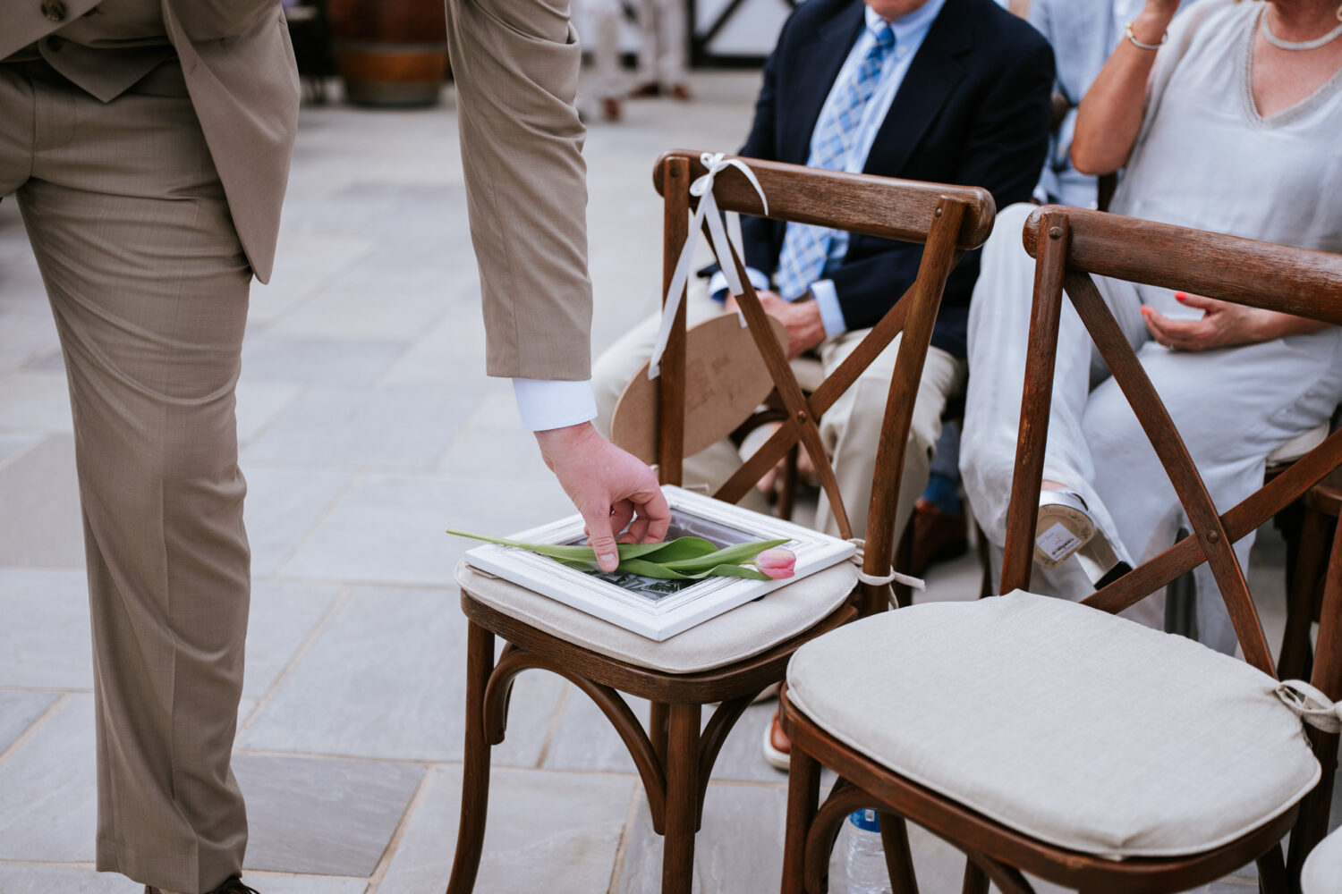groom placing a flower on the mother of the bride's memorial image