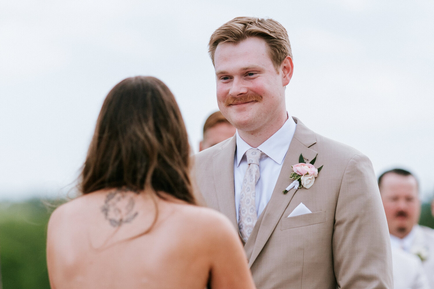 groom smiling while looking at his bride during their wedding ceremony