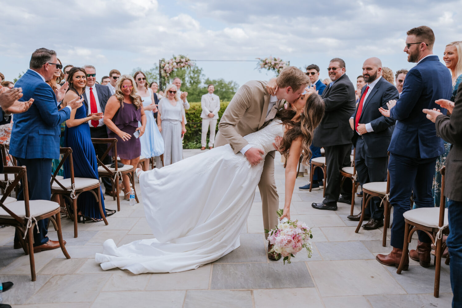 bride and groom share an aisle dip kiss as they leave their wedding shadow creek ceremony