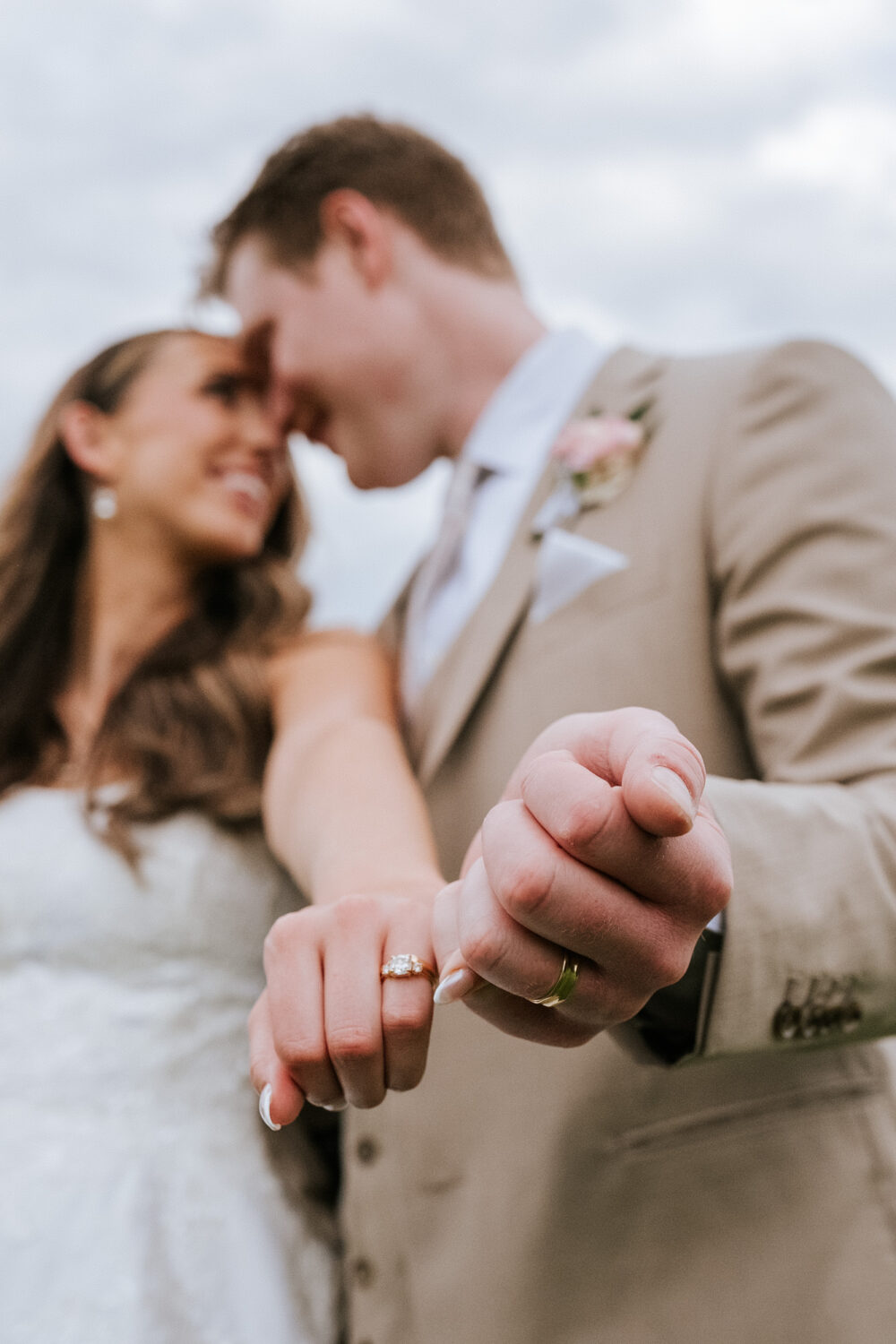 bride and groom showing their wedding rings