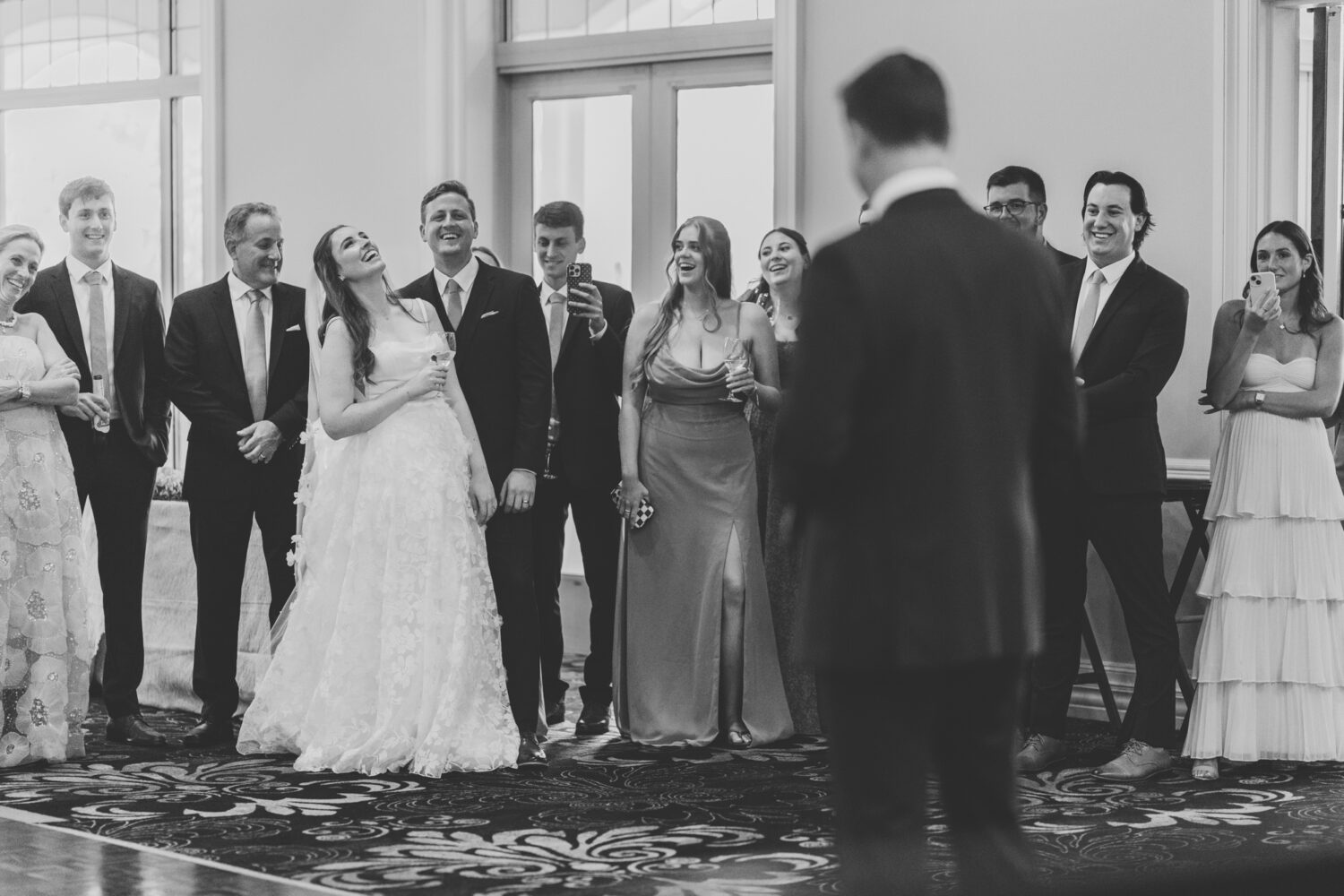 bride and groom laughing while listening to the best man's reception speech
