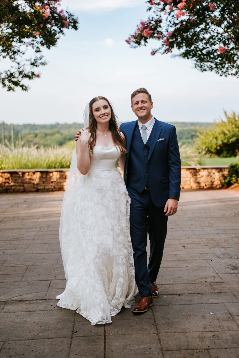 bride and groom smiling together while walking and looking at the camera