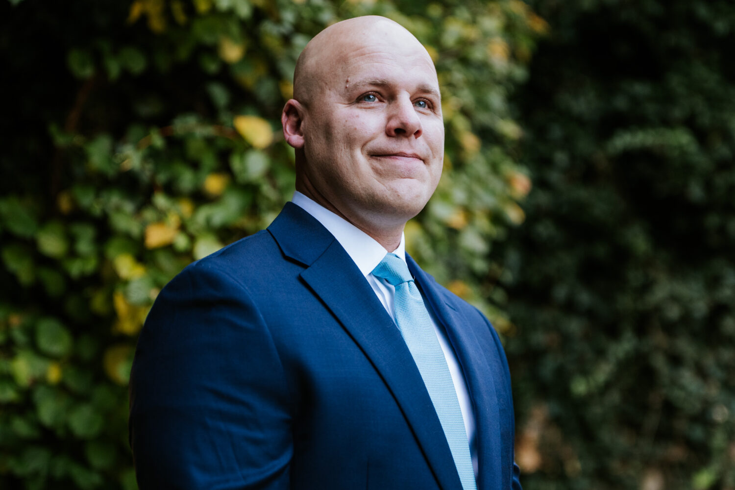 Groom smiling while watching bride during walk down the aisle
