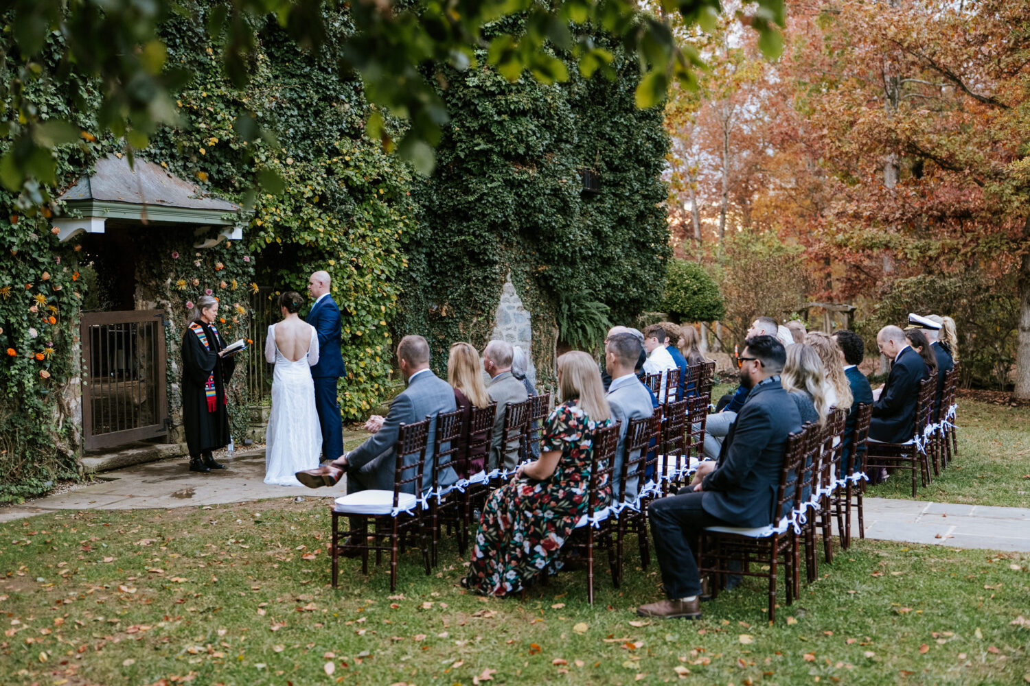 Wide shot of wedding ceremony with guests seated outdoors