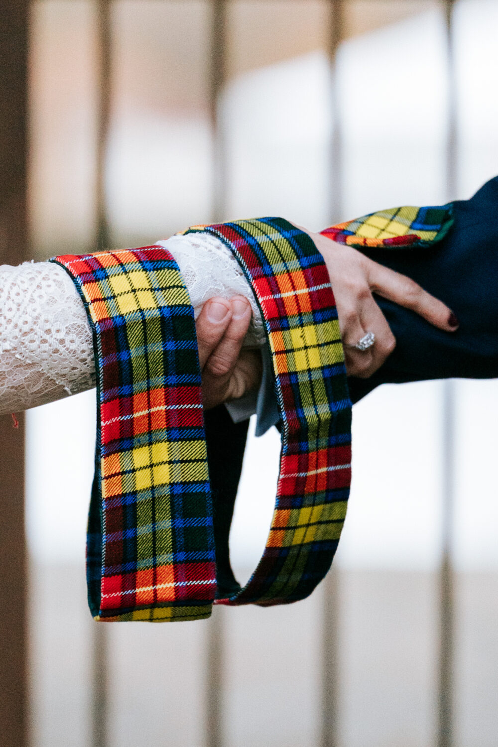 Tight shot of bride and groom holding hands during ceremony