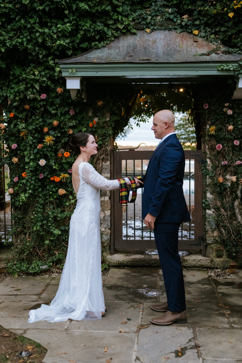 Wide shot of couple holding hands during outdoor ceremony