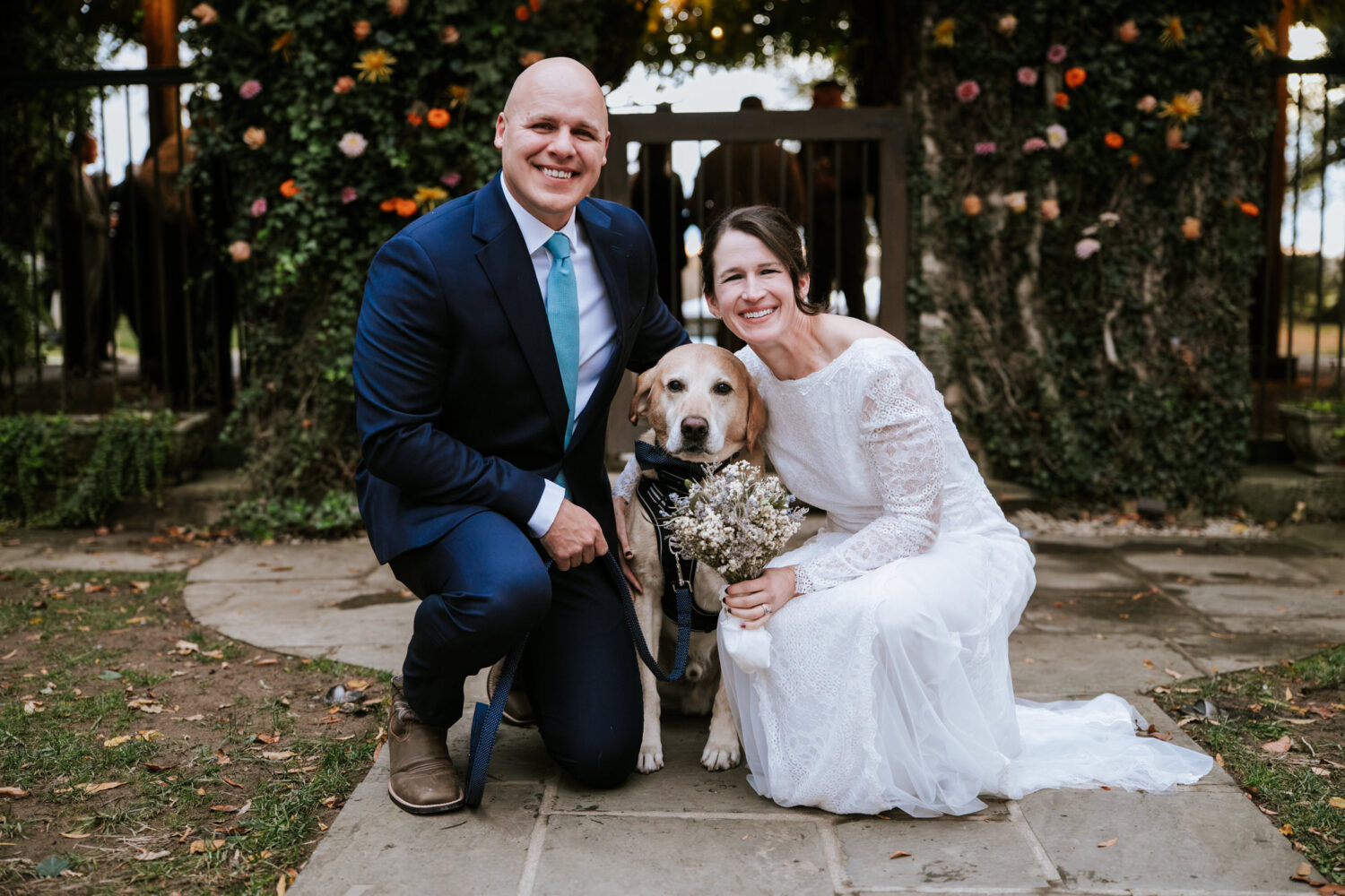 Bride and groom posing with their dog during wedding portraits