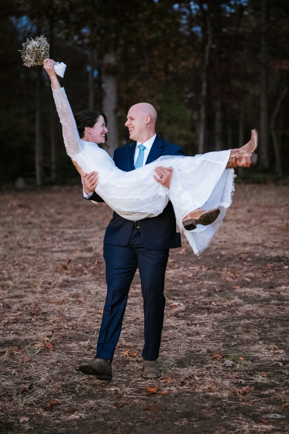 groom picking up bride and cheering together on their wedding day