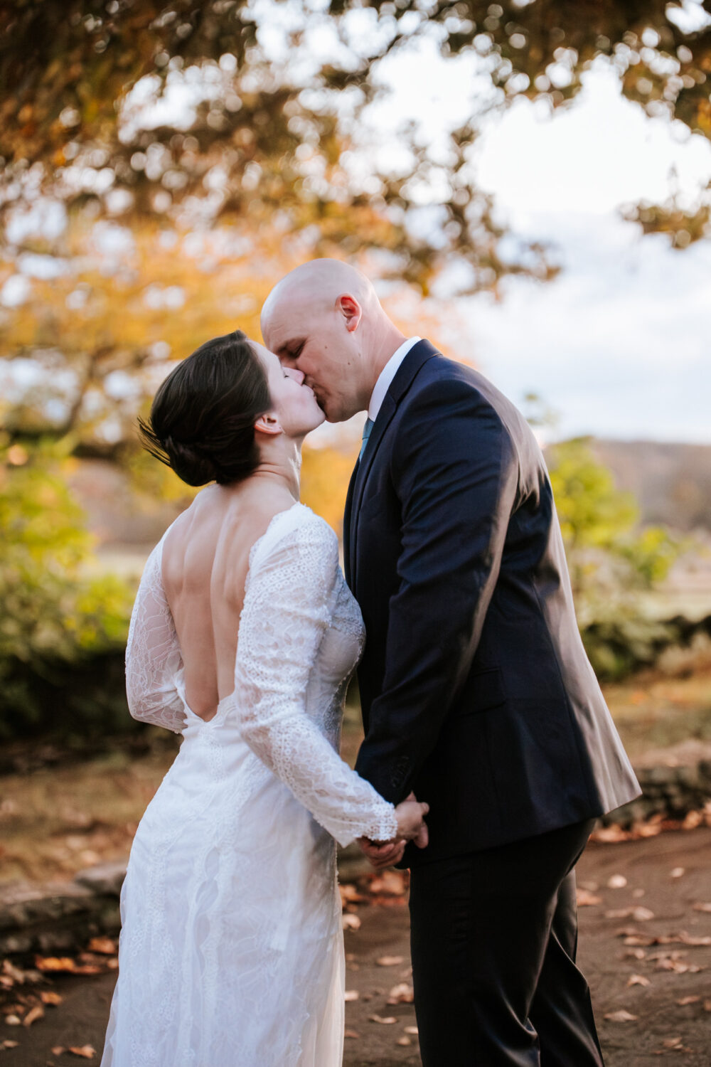 Bride and groom kissing at Goodstone Inn surrounded by fall foliage