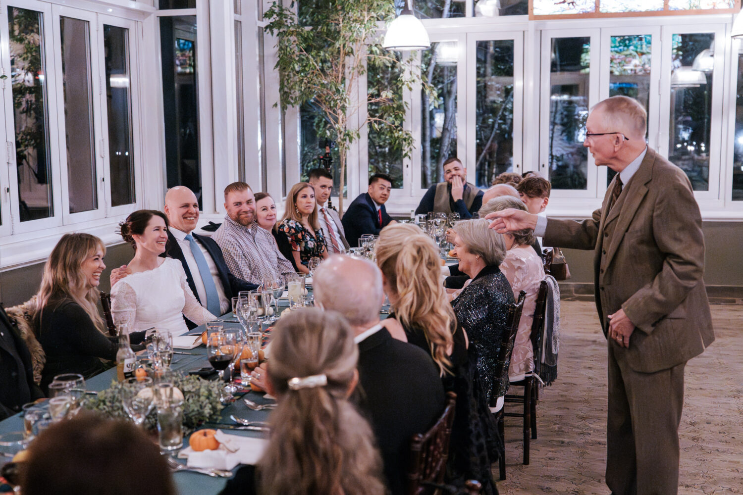 Father of the bride giving funny speech during intimate wedding dinner