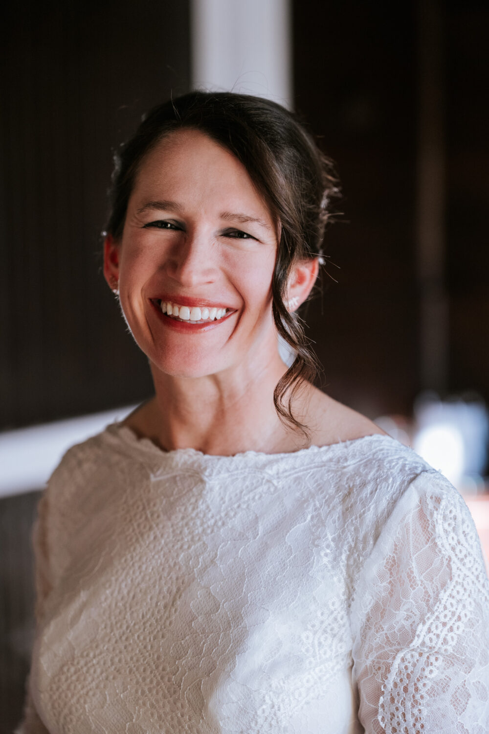 Bride smiling at the camera while getting ready on wedding day