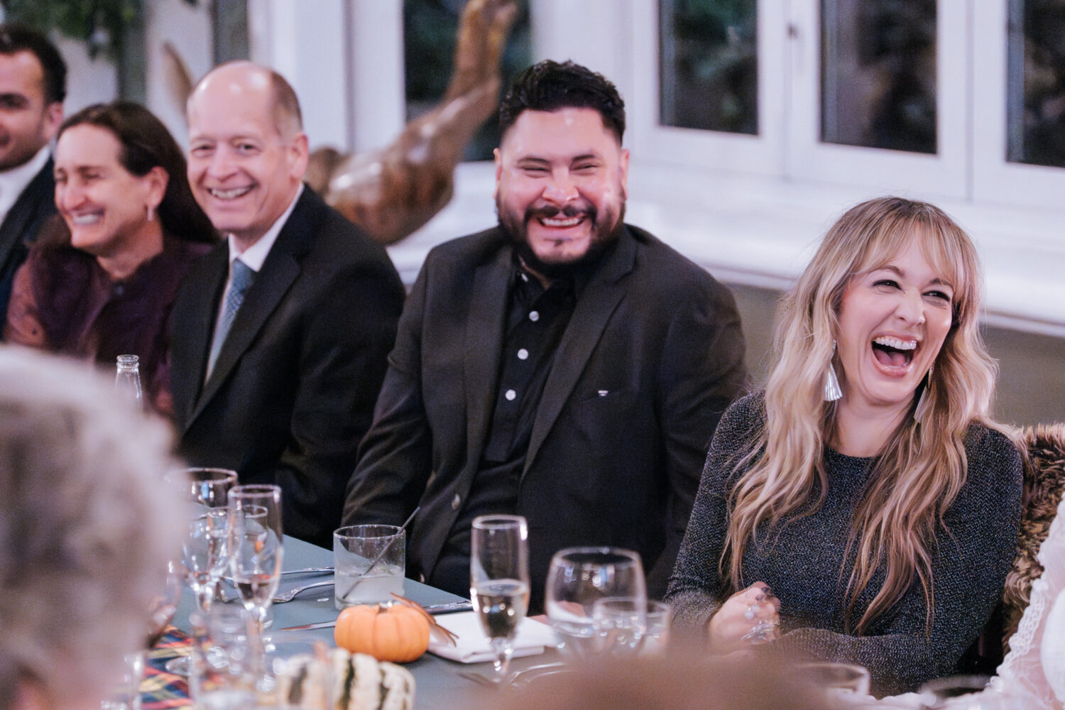 Wedding guests laughing during reception speeches