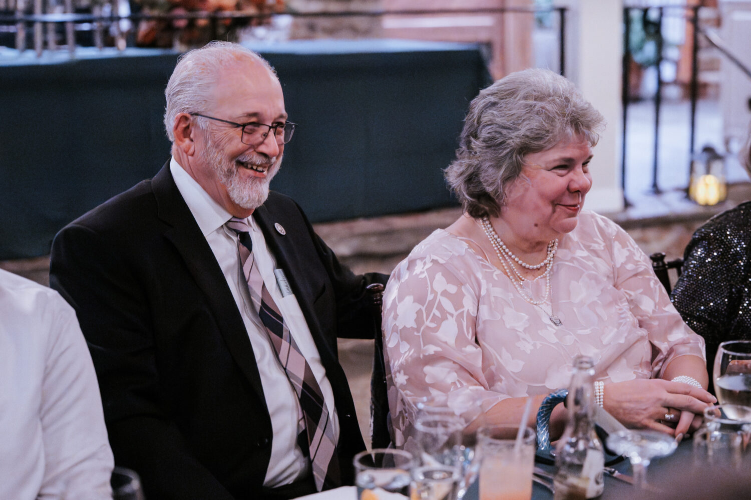 groom's parents laughing during reception speeches