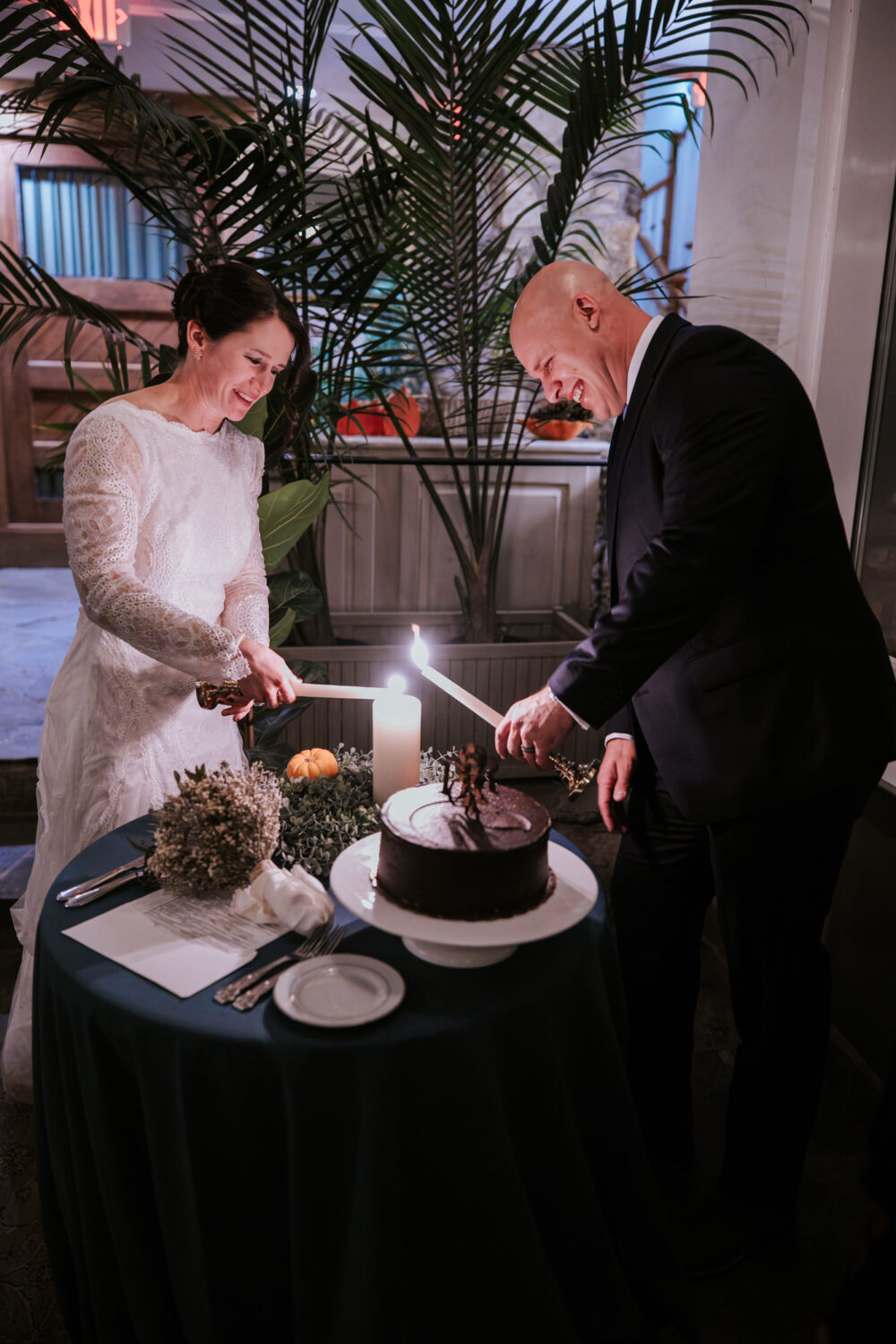 Bride and groom lighting unity candle during wedding reception