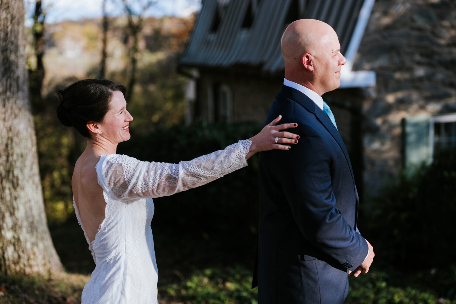 Bride tapping groom’s shoulder during emotional first look moment