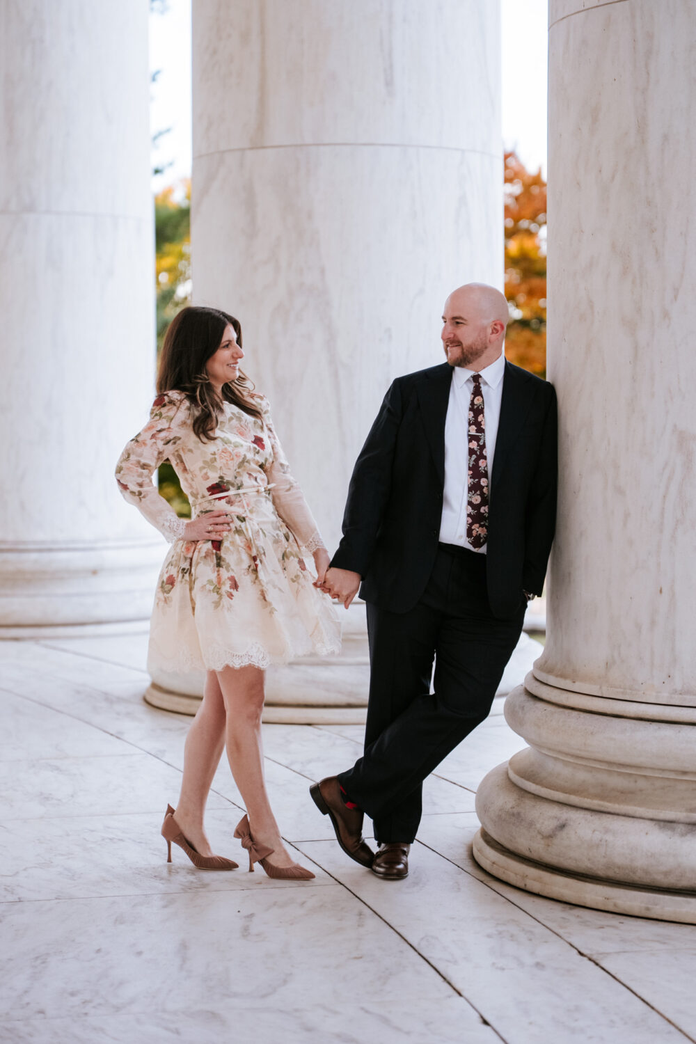 Romantic engagement portrait between the Jefferson Memorial columns in Washington DC