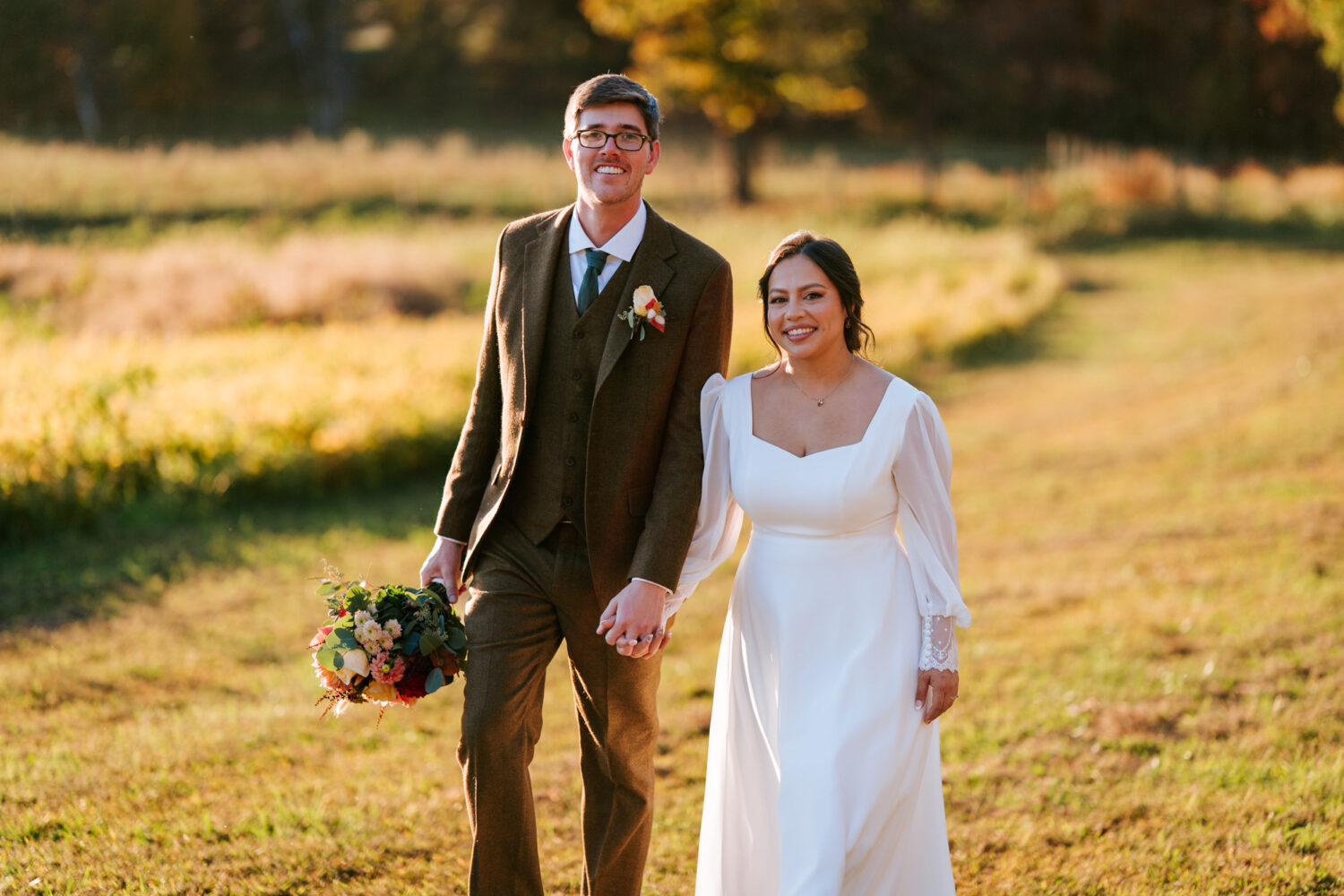 Bride and groom walk through golden fields at Shenandoah Woods wedding
