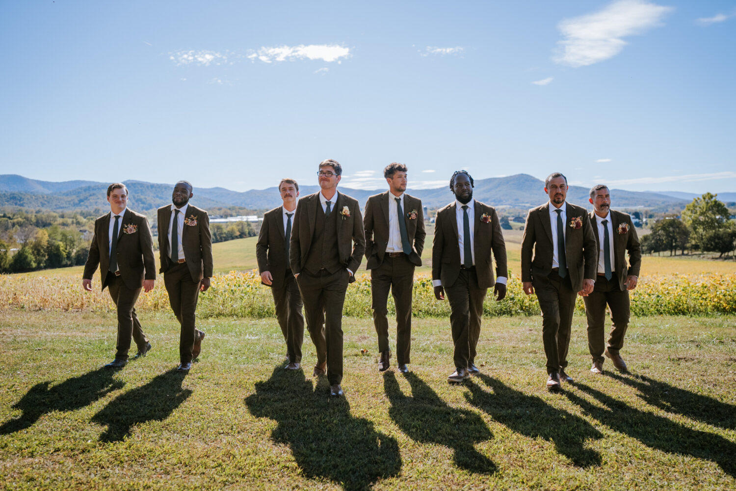 Candid shot of groomsmen walking across scenic Virginia wedding venue
